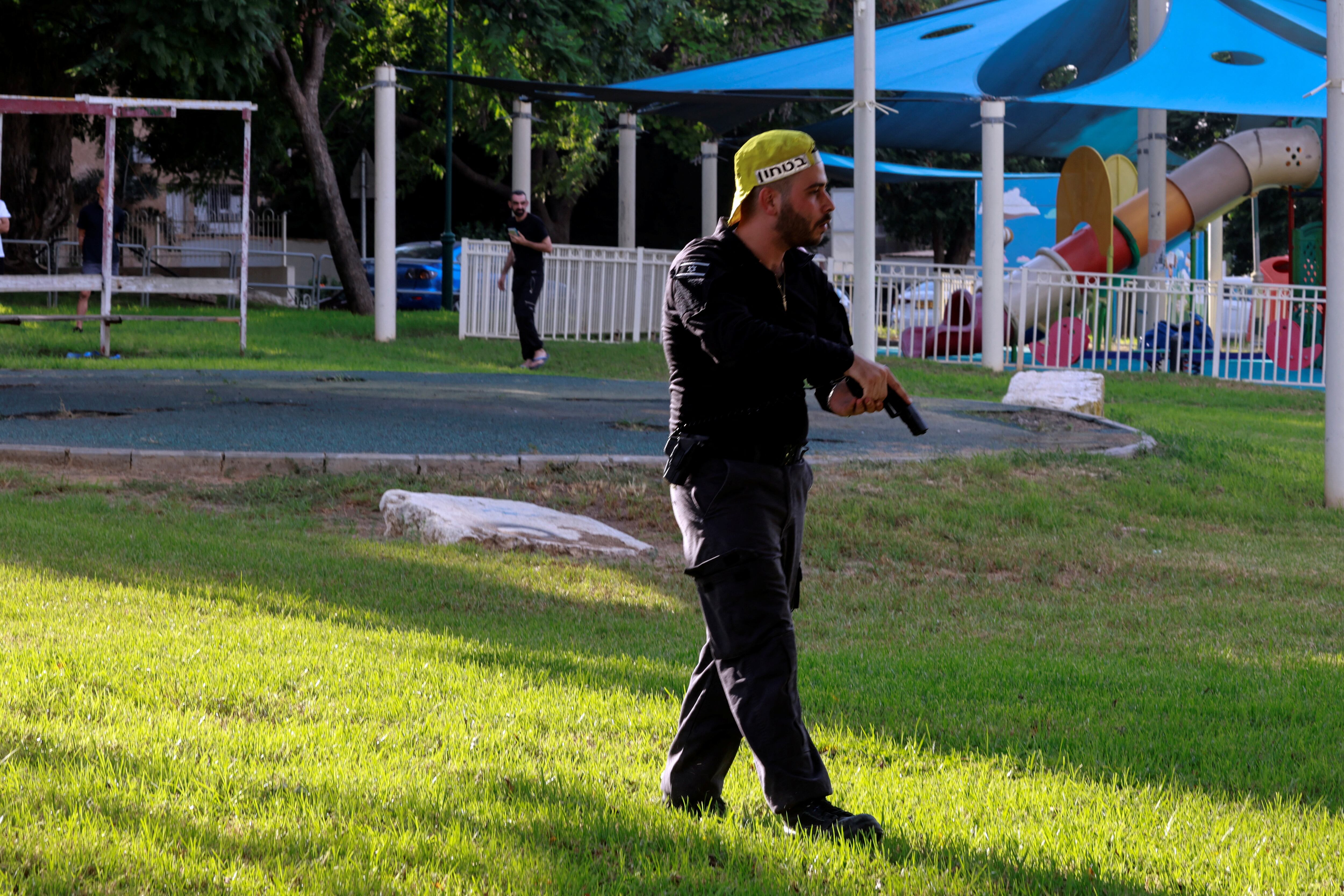 Un funcionario de seguridad israelí sostiene su arma mientras trabaja cerca de un patio de juegos infantil tras la infiltración de Hamas en Sderot