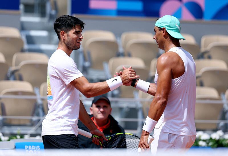 Carlos Alcaraz estrecha la mano de Rafael Nadal durante el entrenamiento. (Claudia Greco/Reuters)