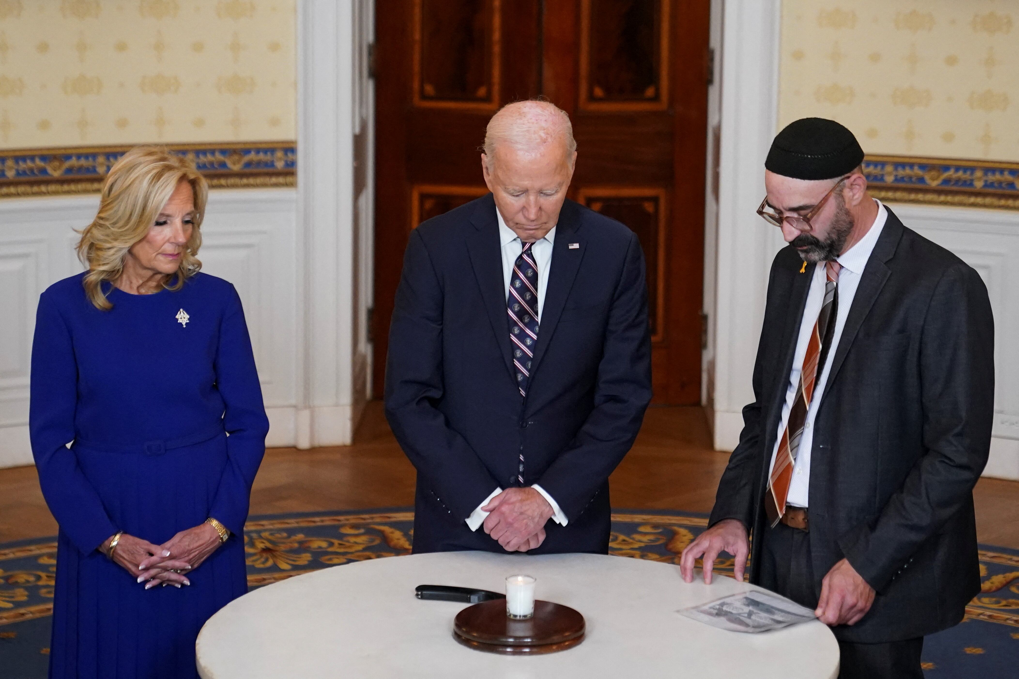 El presidente de Estados Unidos, Joe Biden, flanqueado por la primera dama, Jill Biden, y el rabino Aaron Alexander, de la Congregación Adas Israel, participan en un acto de encendido de velas para conmemorar el aniversario de los ataques de Hamas (REUTERS/Nathan Howard)