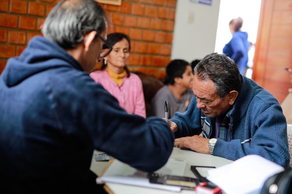 Un funcionario del Reniec ayuda a un ciudadano, adulto mayor, a tramitar su DNI electrónico en el distrito de La Perla, en el Callao.