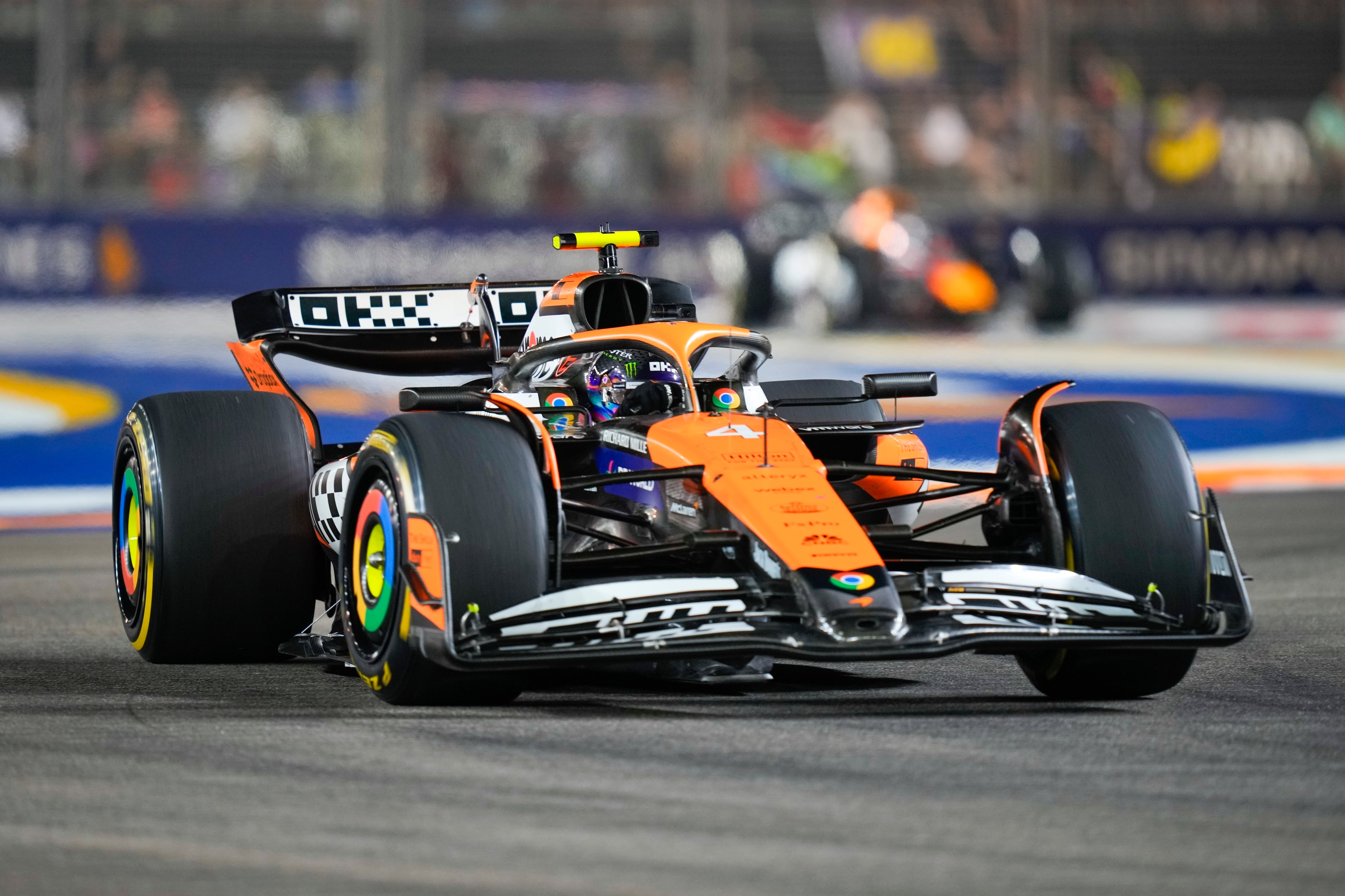 Lando Norris con su McLaren y la decoración retro que lucieron los coches ingleses este fin de semana (AP Foto/Vincent Thian)