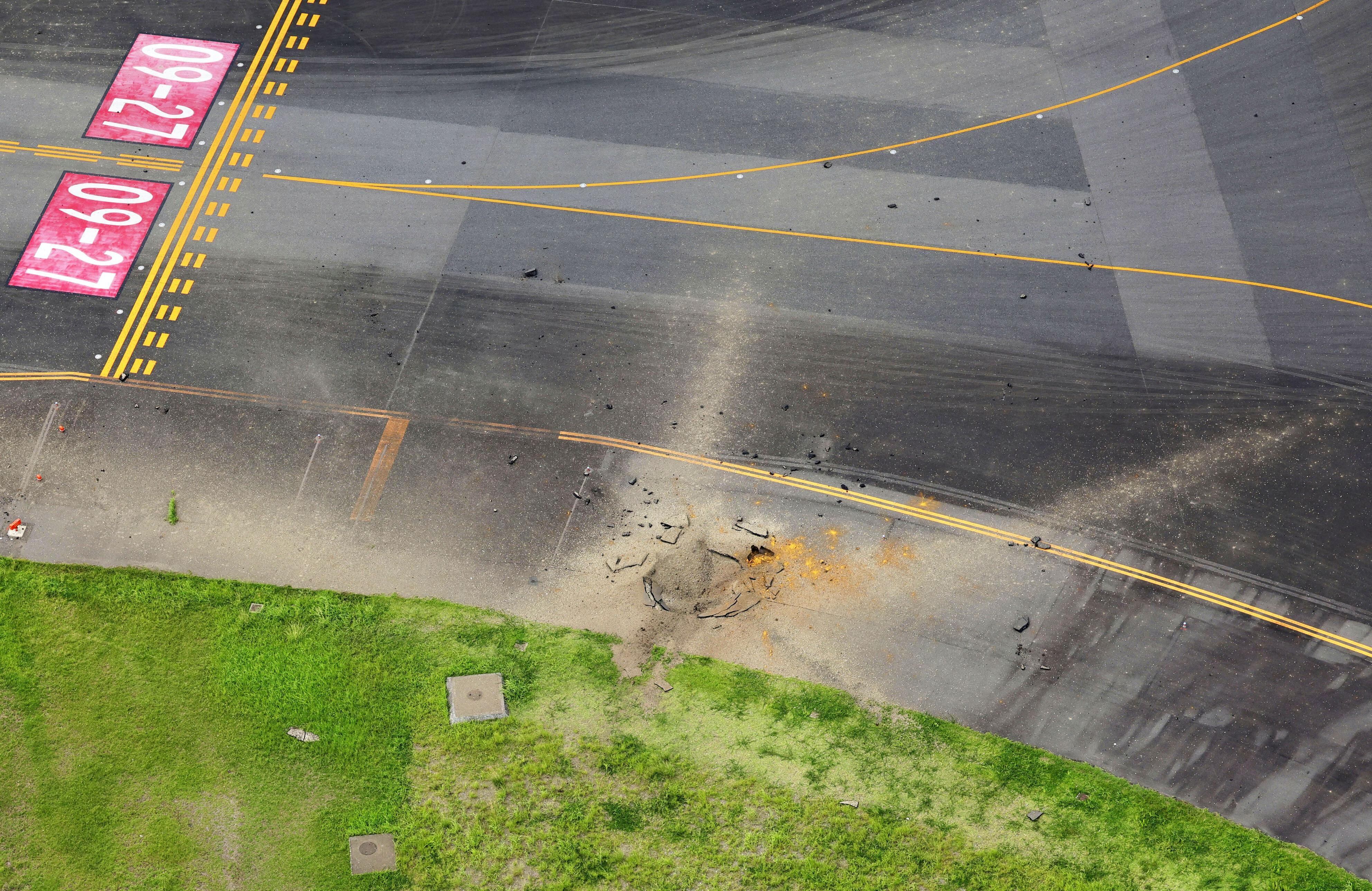 Una vista aérea tomada desde un helicóptero muestra un cráter provocado por una explosión después de que una bomba, que probablemente fue de la Segunda Guerra Mundial, explotara en una pista de rodaje en el aeropuerto de Miyazaki, en Miyazaki, suroeste de Japón, el 2 de octubre de 2024, en esta foto tomada por Kyodo. Crédito obligatorio Kyodo vía REUTERS