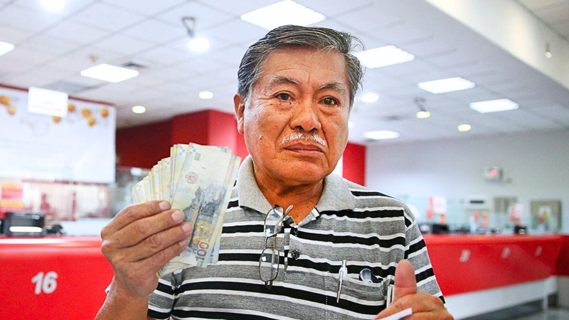 hombre adultos mayor con billetes de 100 soles en la mano en el Banco de la Nación