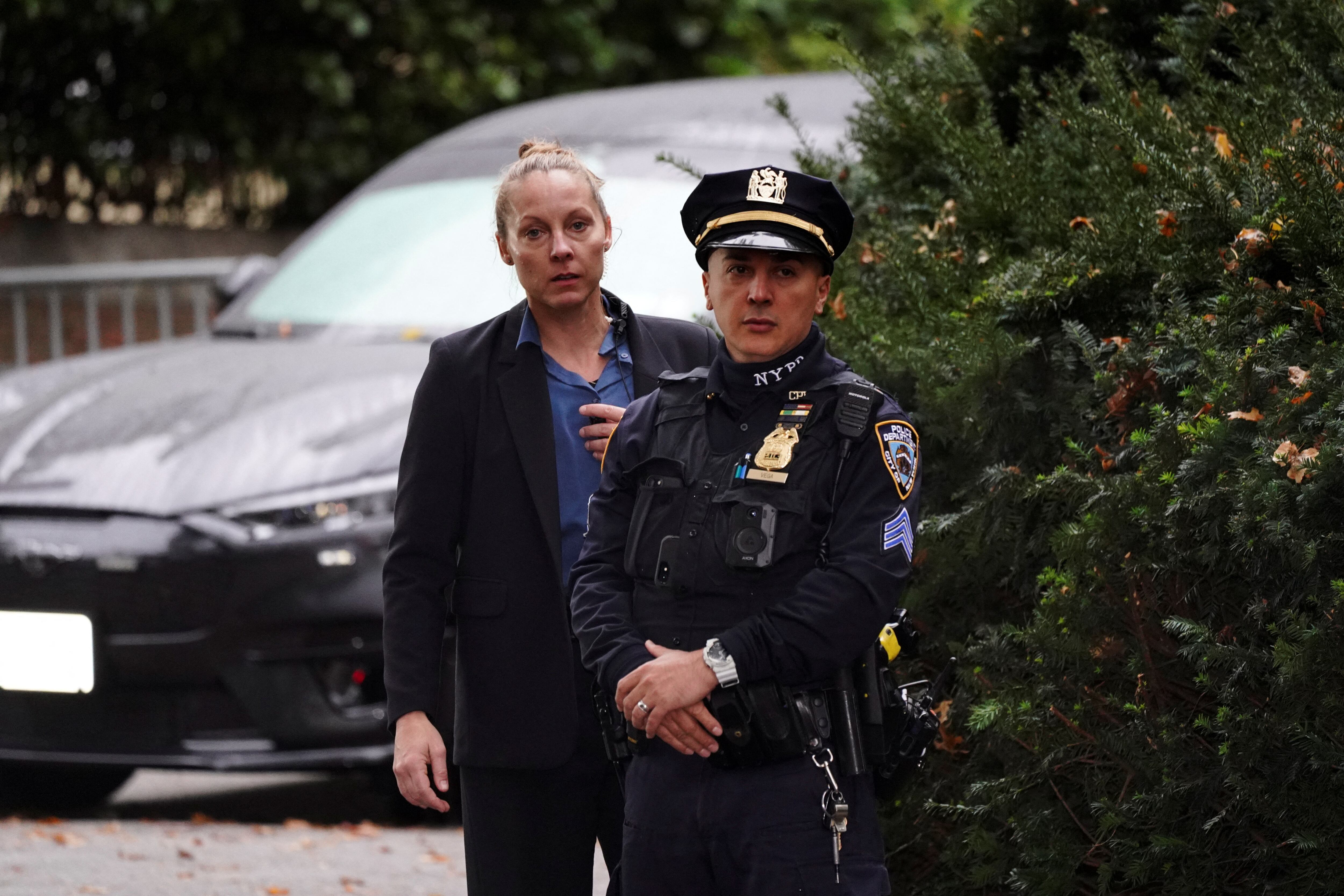 Un agente de la ley federal (izq.) dirige a un agente del Departamento de Policía de Nueva York que hace guardia en el exterior de Gracie Mansion, la residencia oficial del alcalde de la ciudad de Nueva York, Eric Adams, en medio de informes de que será acusado de delitos federales en la ciudad de Nueva York, EE. UU., el 26 de septiembre de 2024. REUTERS/Bing Guan