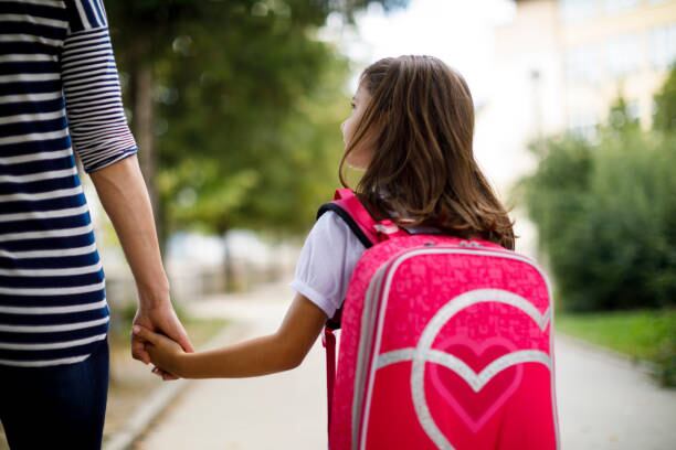 niña va a la escuela junto a su madre