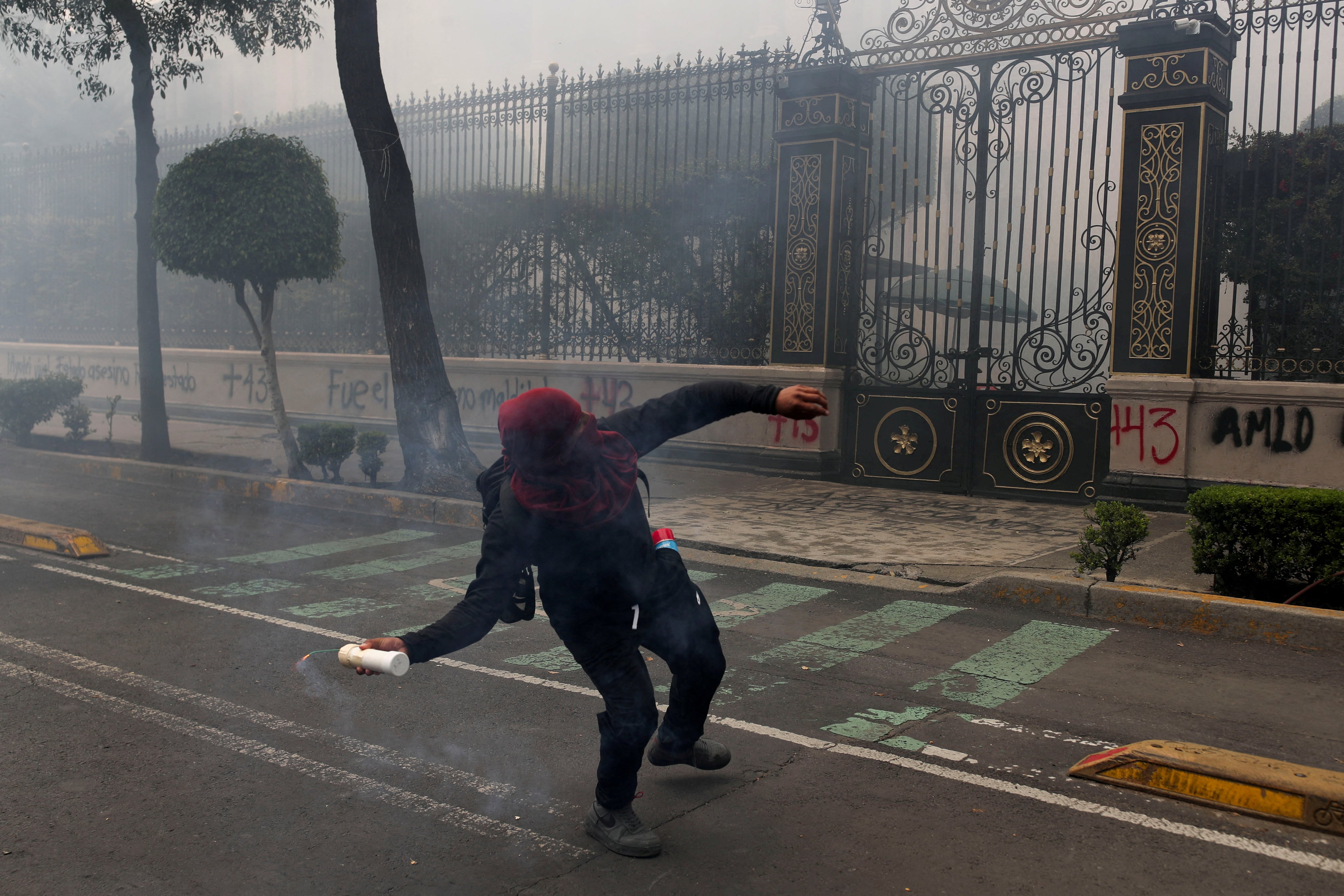 Un manifestante arroja explosivos de fabricación casera al edificio de la Segob durante la protesta. (REUTERS/Henry Romero)