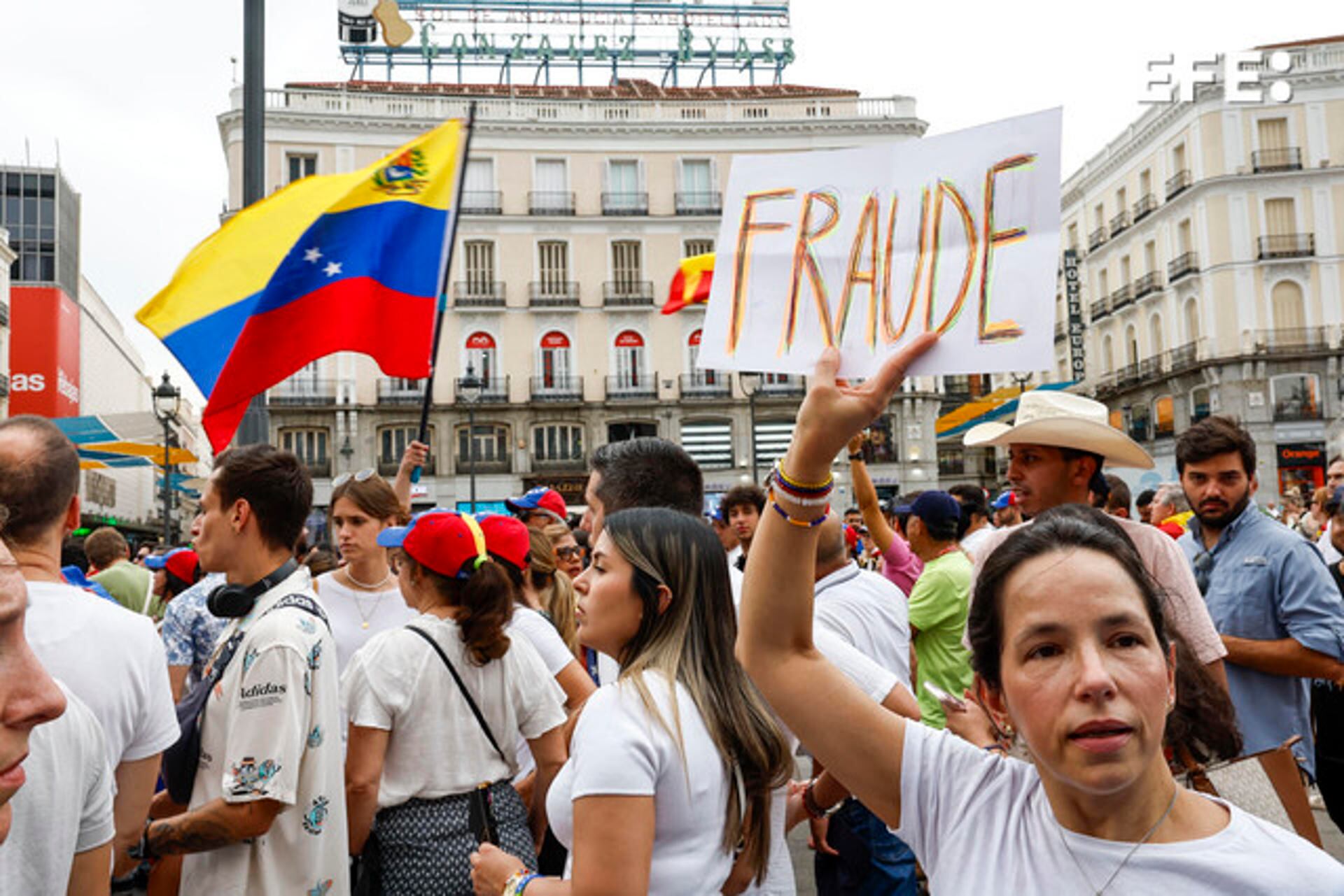 Una mujer sostiene una pancarta en la manifestación convocada por la oposición venezolana un día después de las elecciones en el país, este lunes en Madrid