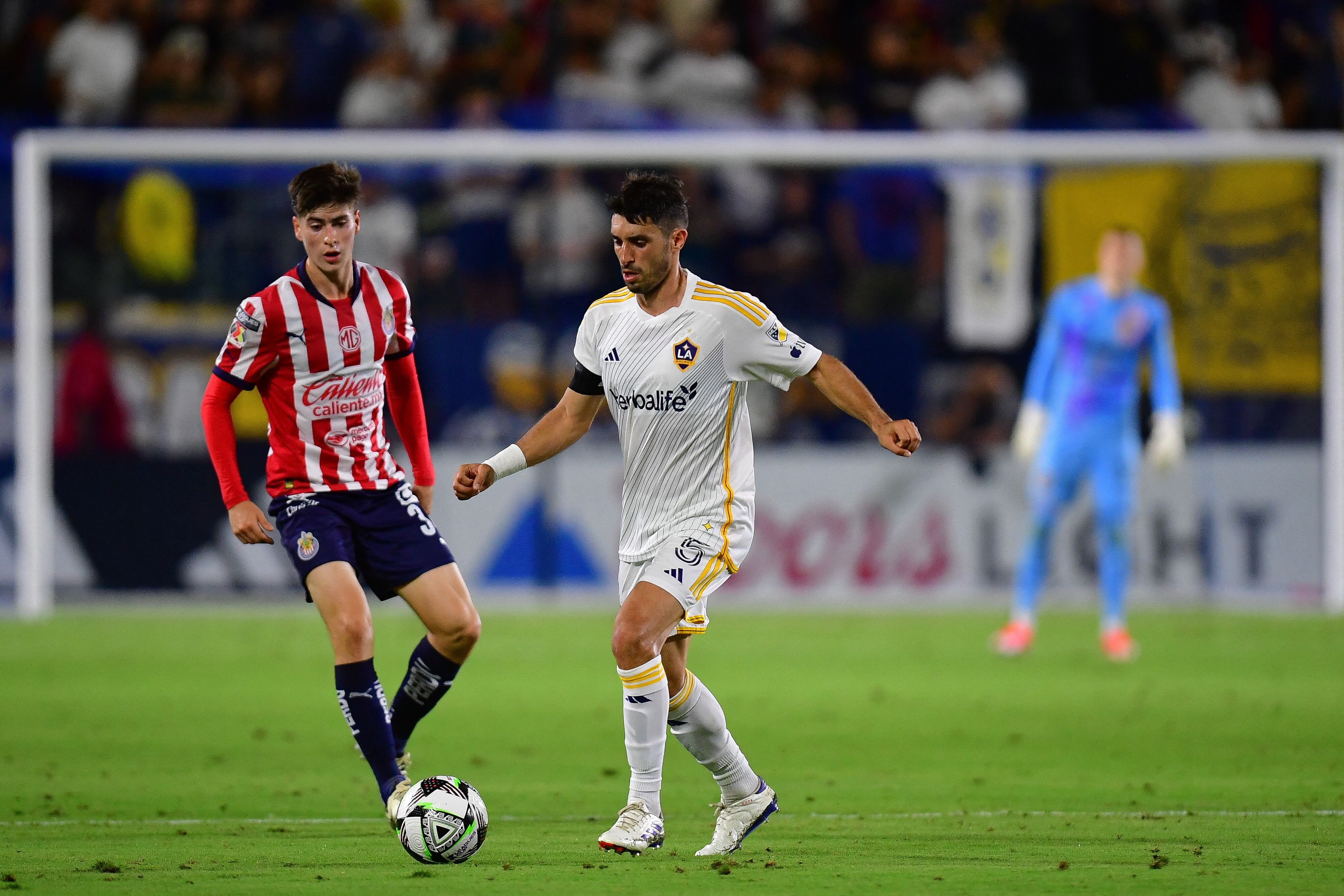 August 4, 2024; Carson, California, USA; LA Galaxy midfielder Gaston Brugman (5) moves the ball against Chivas during the second half at Dignity Health Sports Park. Mandatory Credit: Gary A. Vasquez-USA TODAY Sports