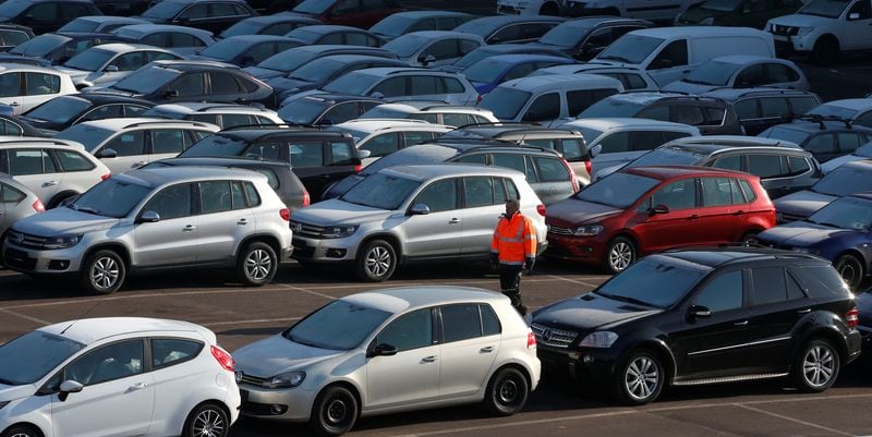 Un trabajador entre coches de segunda mano en el recinto de la empresa Auto1.com, a 28 de enero de 2017. (REUTERS/Fabrizio Bensch)