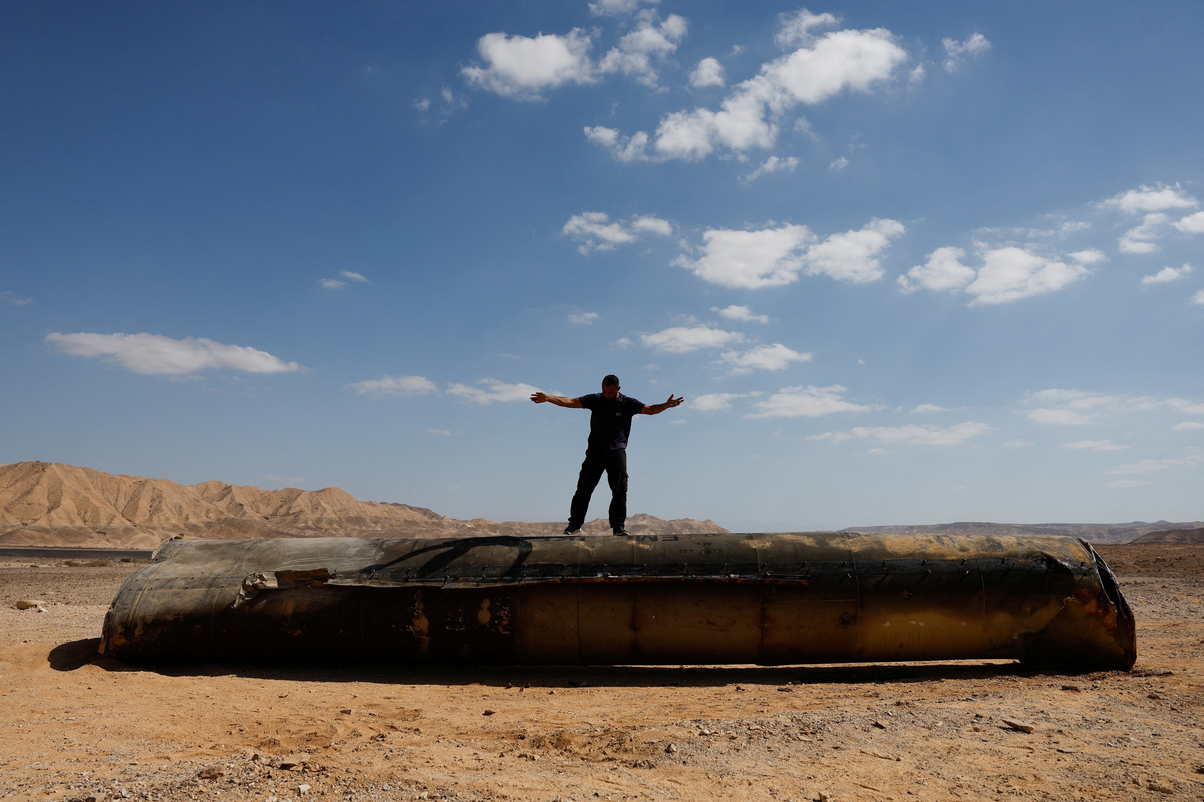 Varias personas se tomaron fotos sobre lo que quedó de los proyectiles lanzados por Irán