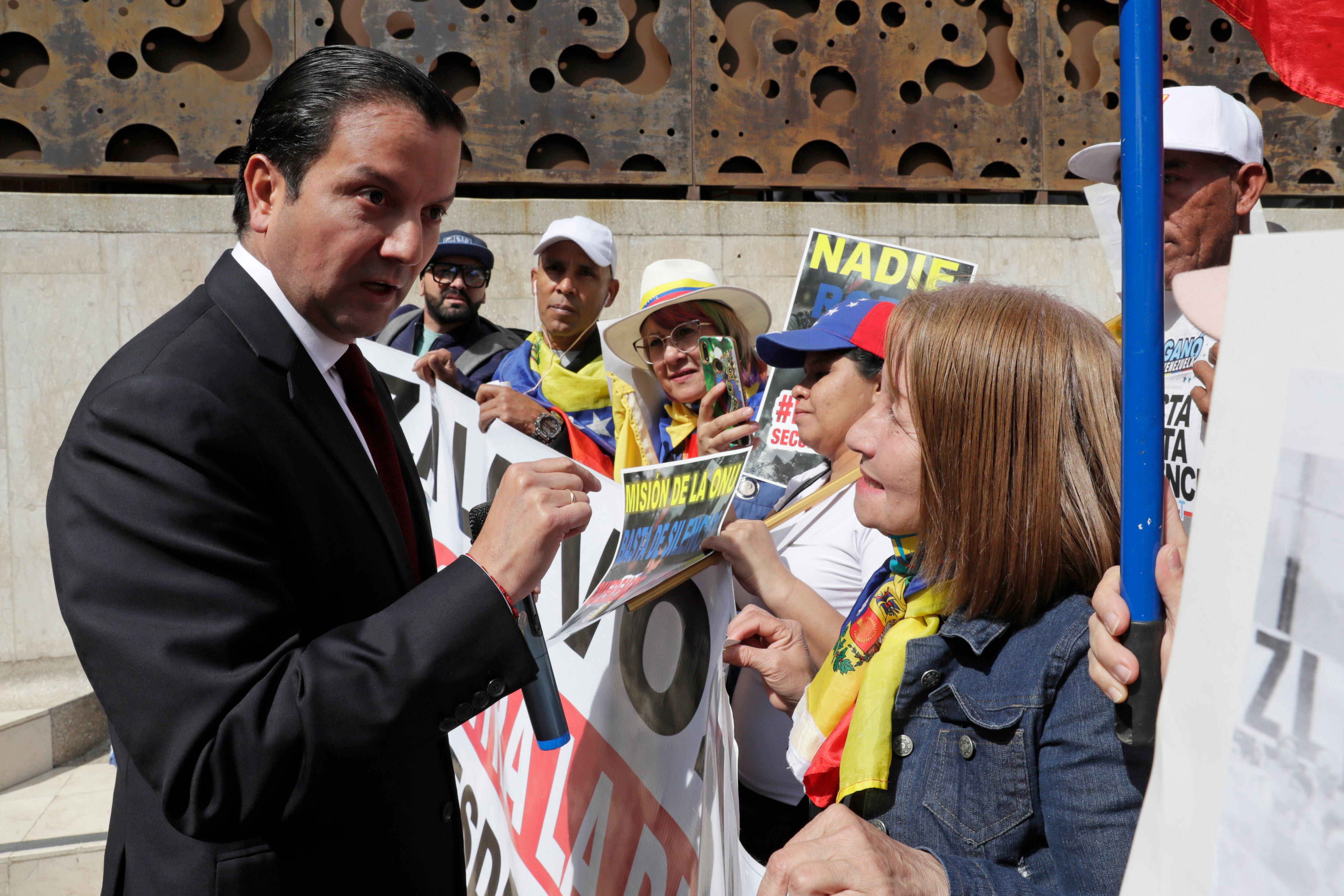 El senador David Luna (i), habla con un grupo de ciudadanos venezolanos que participa en un plantón frente a la oficina de la ONU para los Derechos Humanos, este martes en Bogotá (Colombia). EFE/ Carlos Ortega
