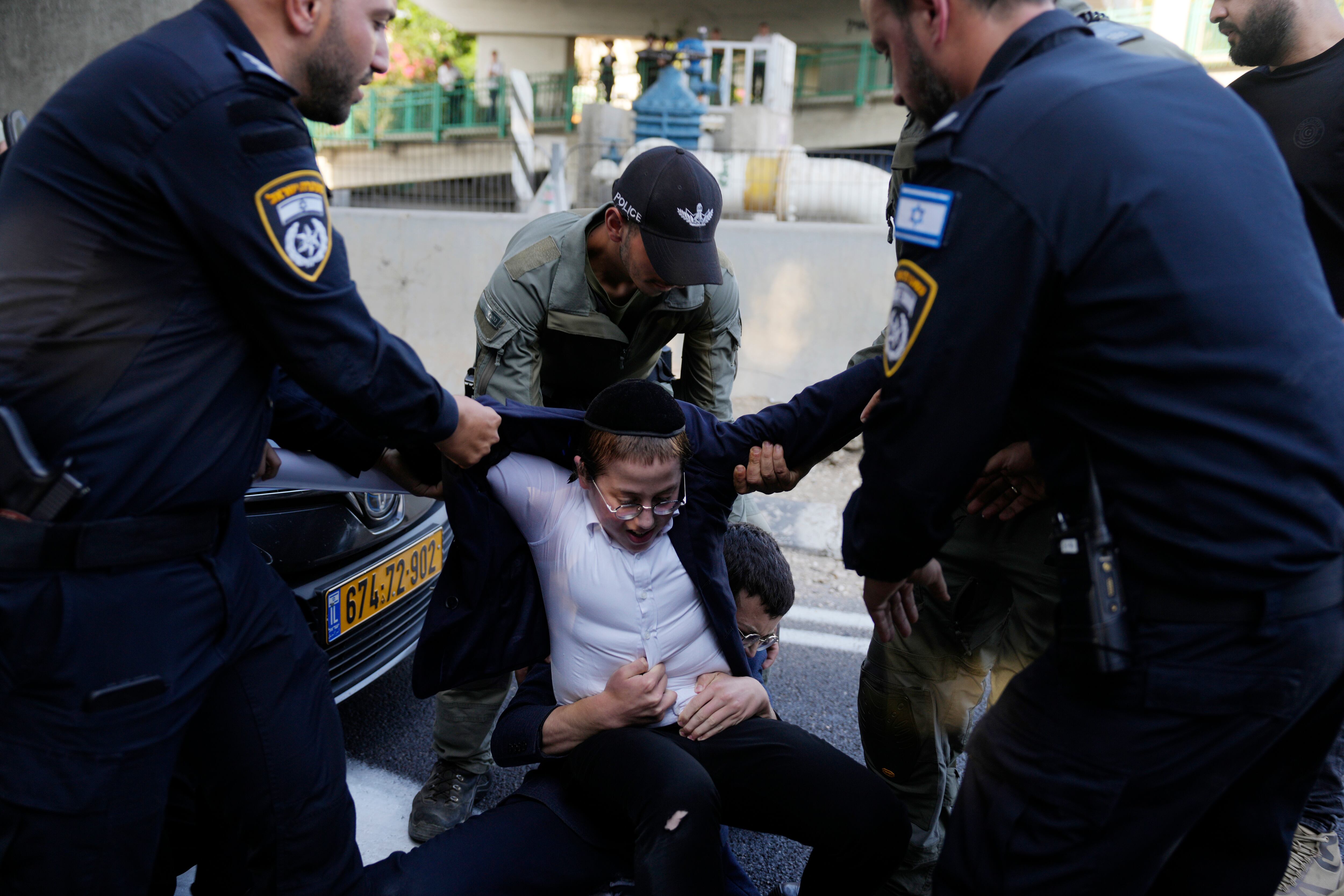 La policía israelí retira a jóvenes judíos ultraortodoxos que bloquean una carretera para protestar contra el reclutamiento militar en Bnei Brak, cerca de Tel Aviv, Israel, este martes (Foto AP/Ohad Zwigenberg)