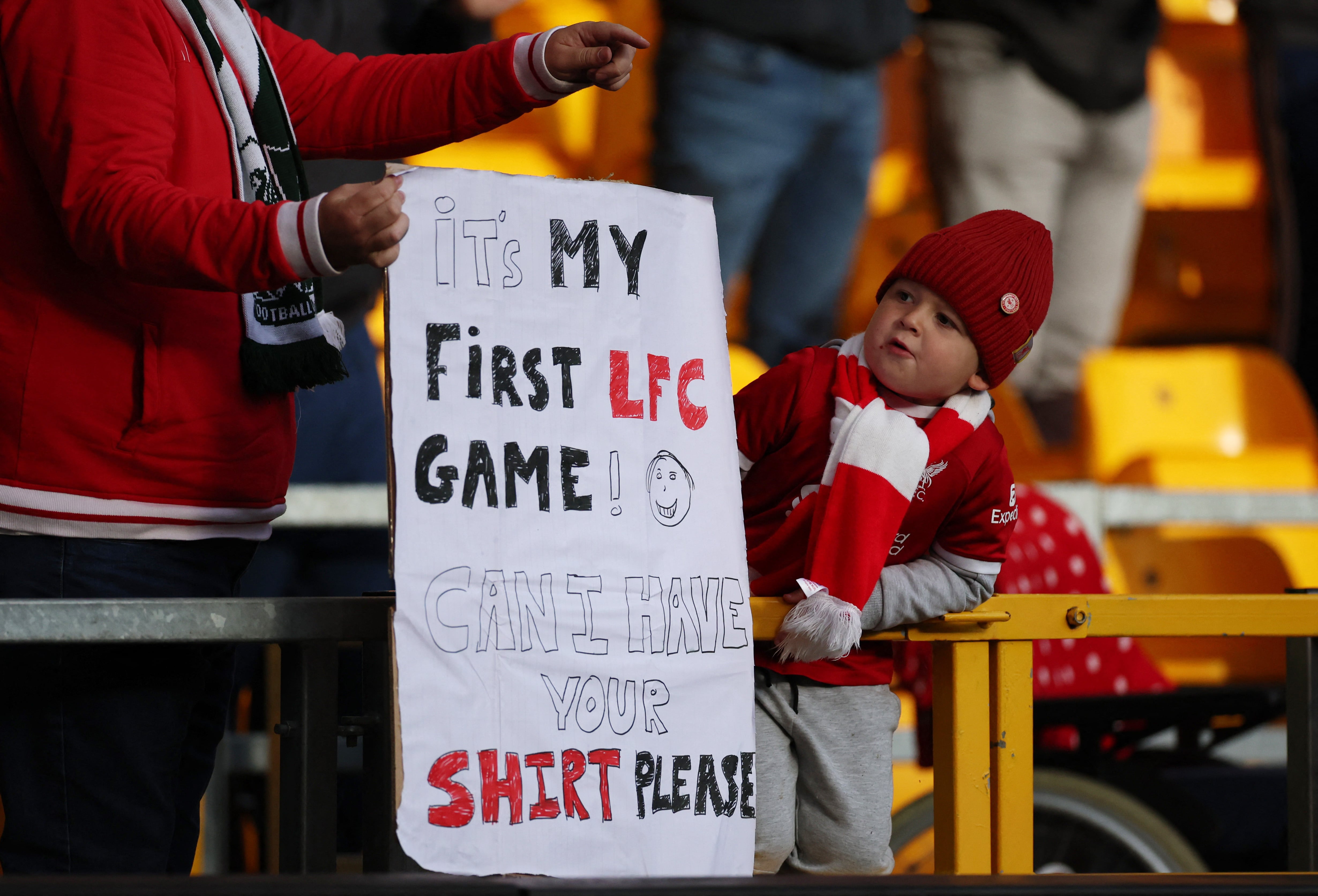 Un niño junto a su padre pidiendo a su ídolo como regalo la camiseta en la previa del partido-crédito Phil Noble/REUTERS 