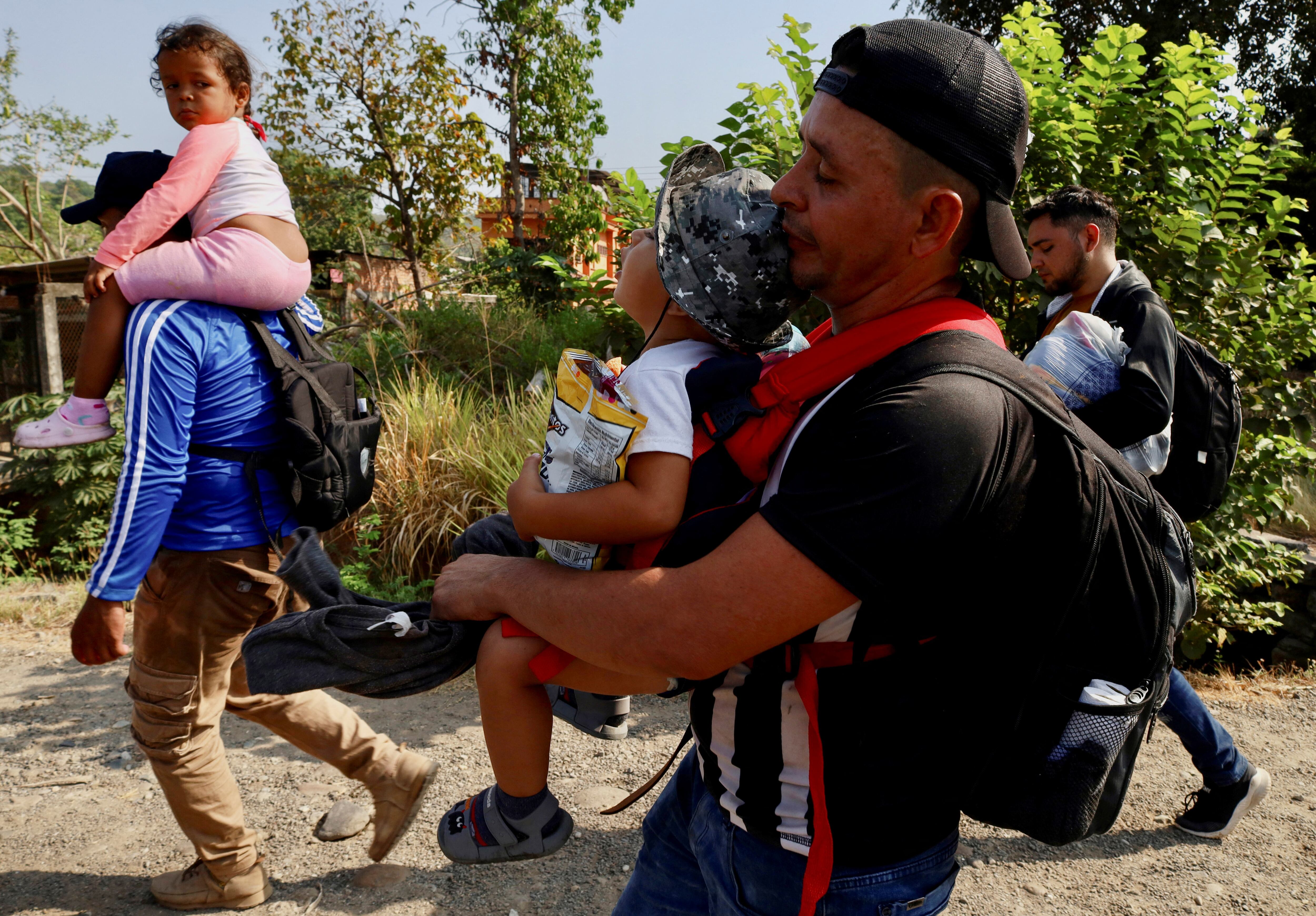 Heberto Cigarroa, un migrante venezolano, sostiene a su hijo José Carlos junto a otros migrantes de diferentes nacionalidades mientras caminan hacia Estados Unidos en una caravana llamada "El Vía Crucis del Migrante", en Tapachula, México, el 25 de marzo de 2024. REUTERS/Jose Torres