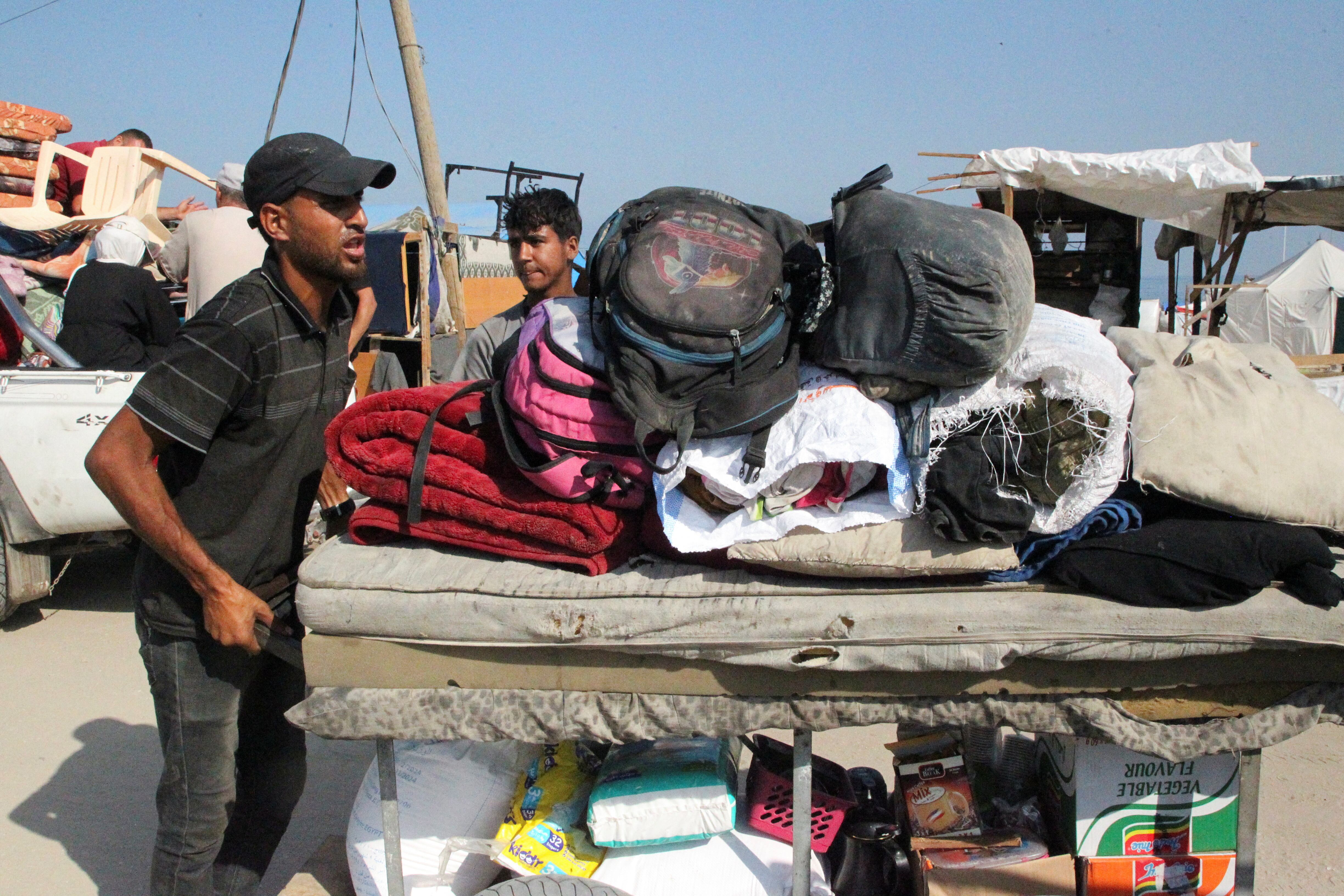 Palestinos viajan a pie con sus pertenencias mientras huyen de Rafah debido a una operación militar israelí (REUTERS/Hatem Khaled)