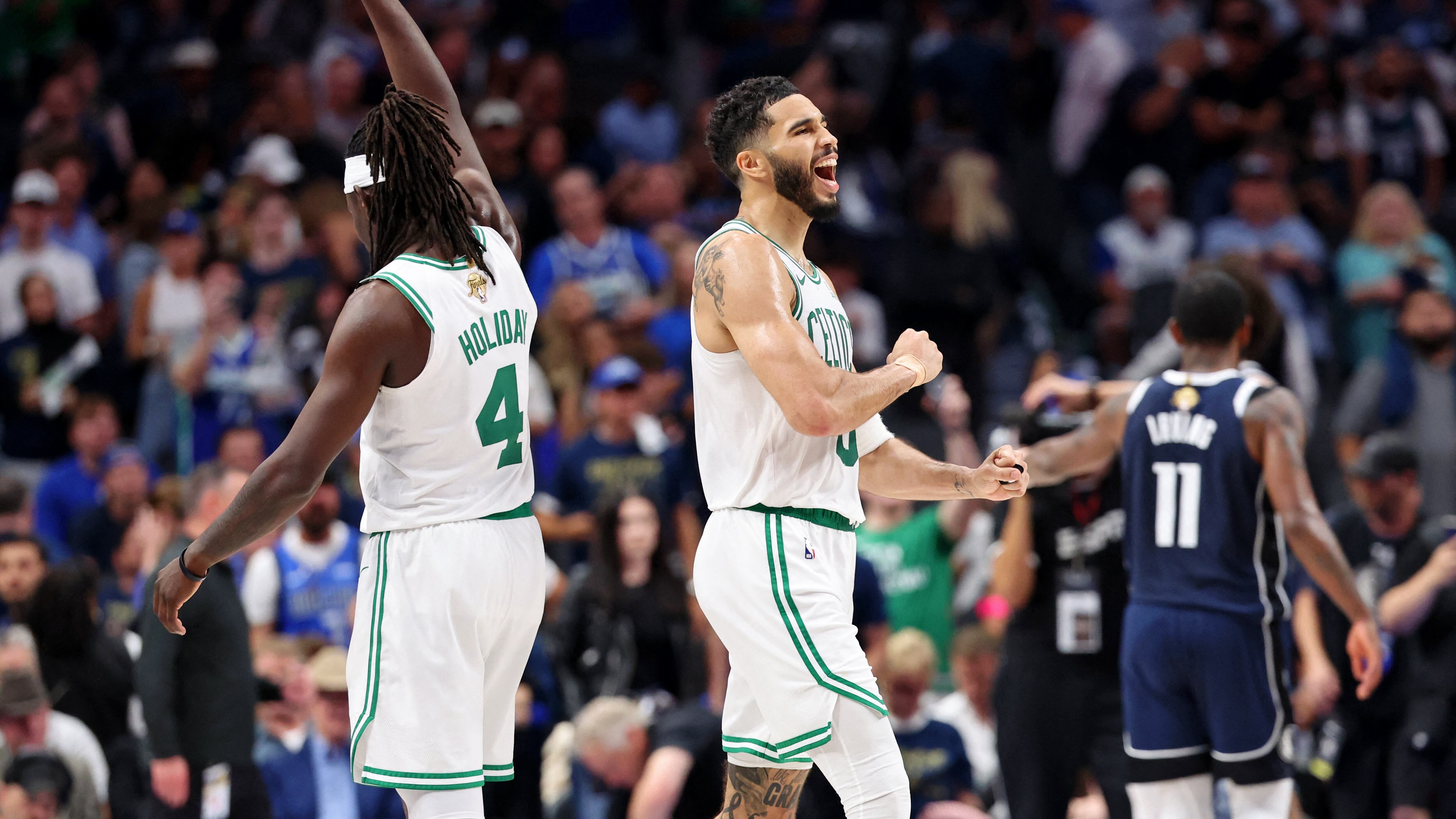 Jrue Holiday (4) y Jayson Tatum (0) de Boston Celtics celebran después de su victoria contra los Dallas Mavericks en el tercer juego de las Finales de la NBA de 2024 en el American Airlines Center (Crédito obligatorio: Kevin Jairaj-USA TODAY Deportes)