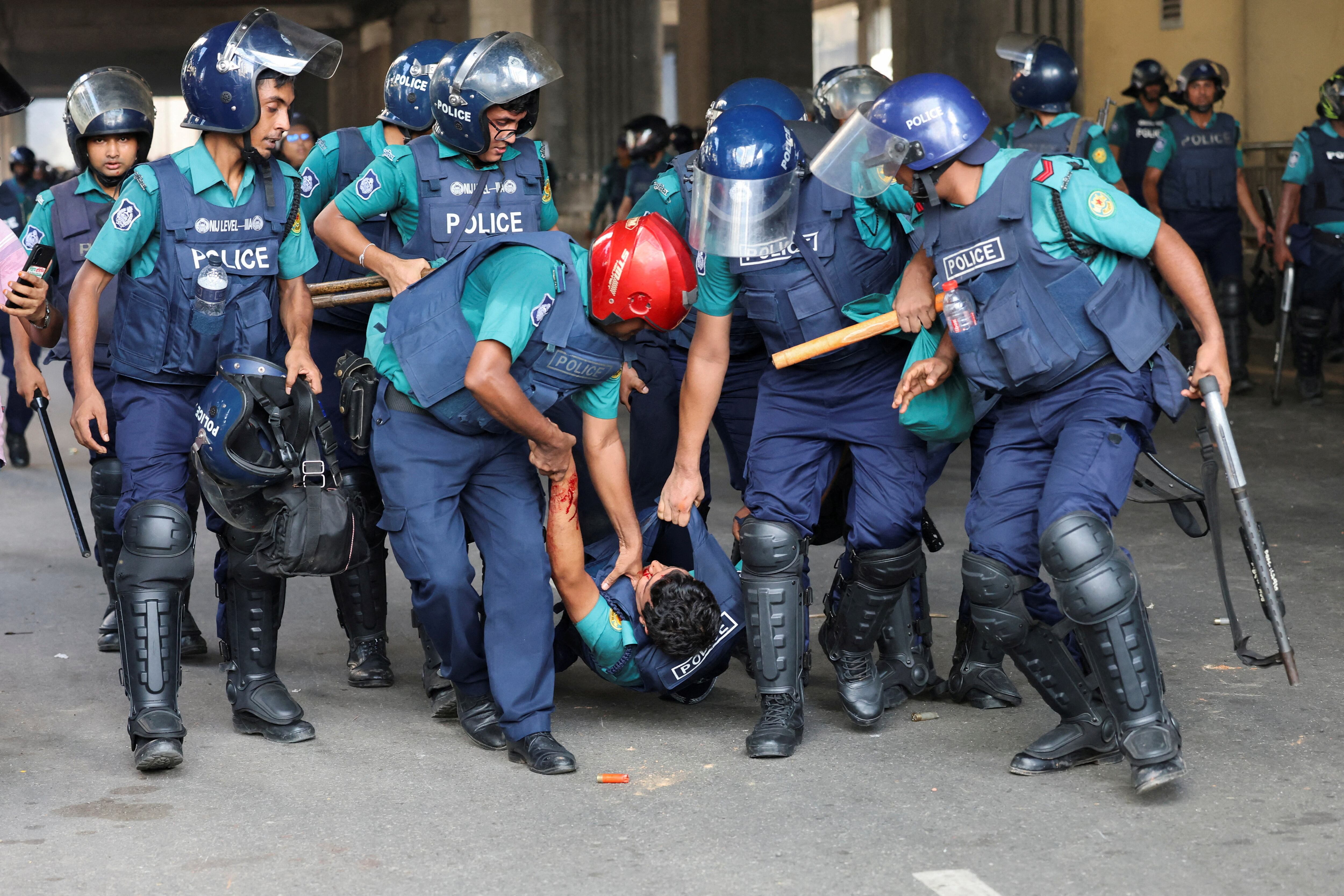 Un manifestante corre junto a una cabina de policía destrozada durante la protesta (REUTERS/Mohammad Ponir Hossain)
