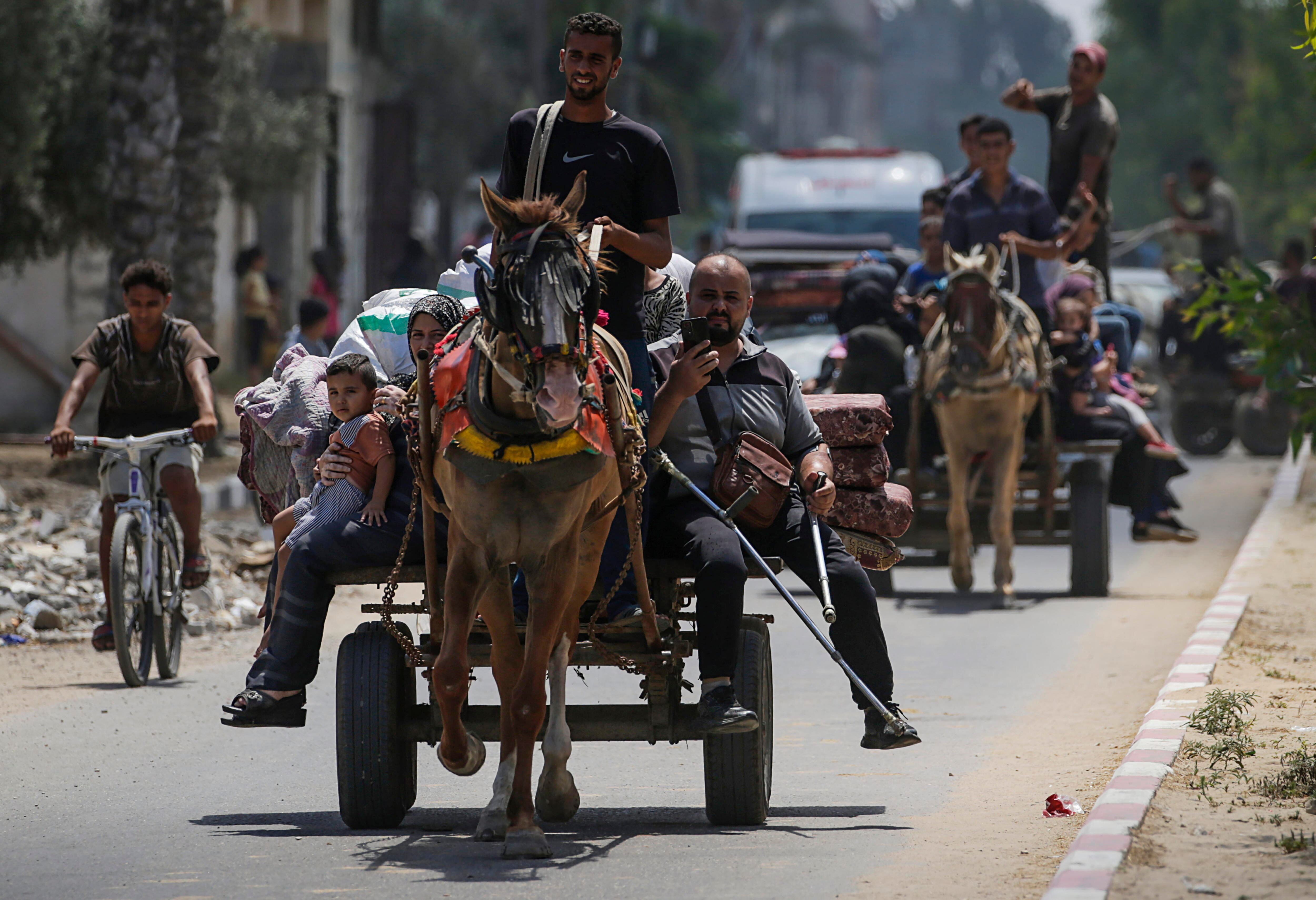 Palestinos desplazados internos huyen con sus pertenencias tras una orden de evacuación emitida por el ejército israelí, en el este de Deir Al Balah, en el centro de la Franja de Gaza (EFE/EPA/MOHAMMED SABER)
