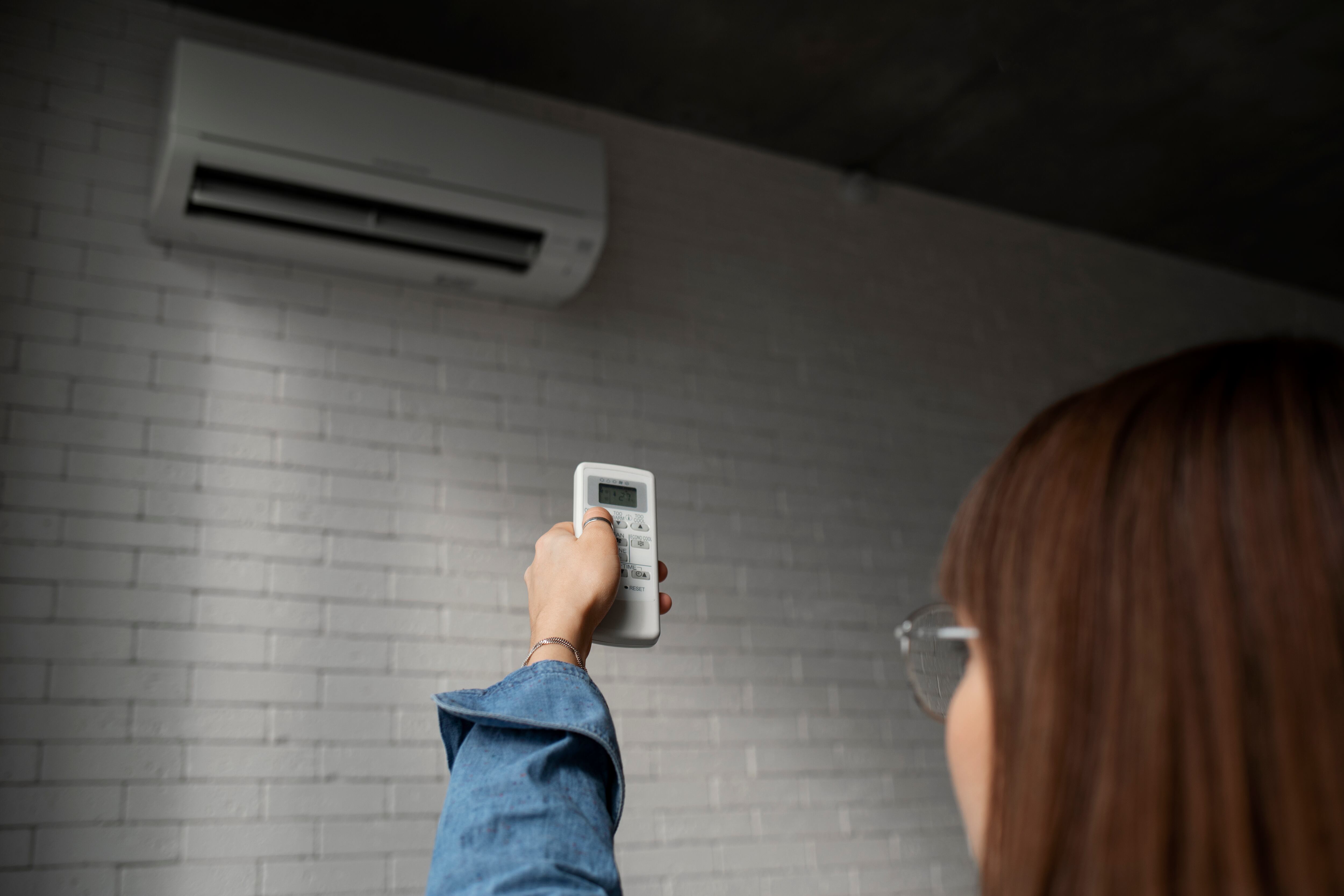 Una mujer enciende en su casa el aire acondicionado. (Freepik)