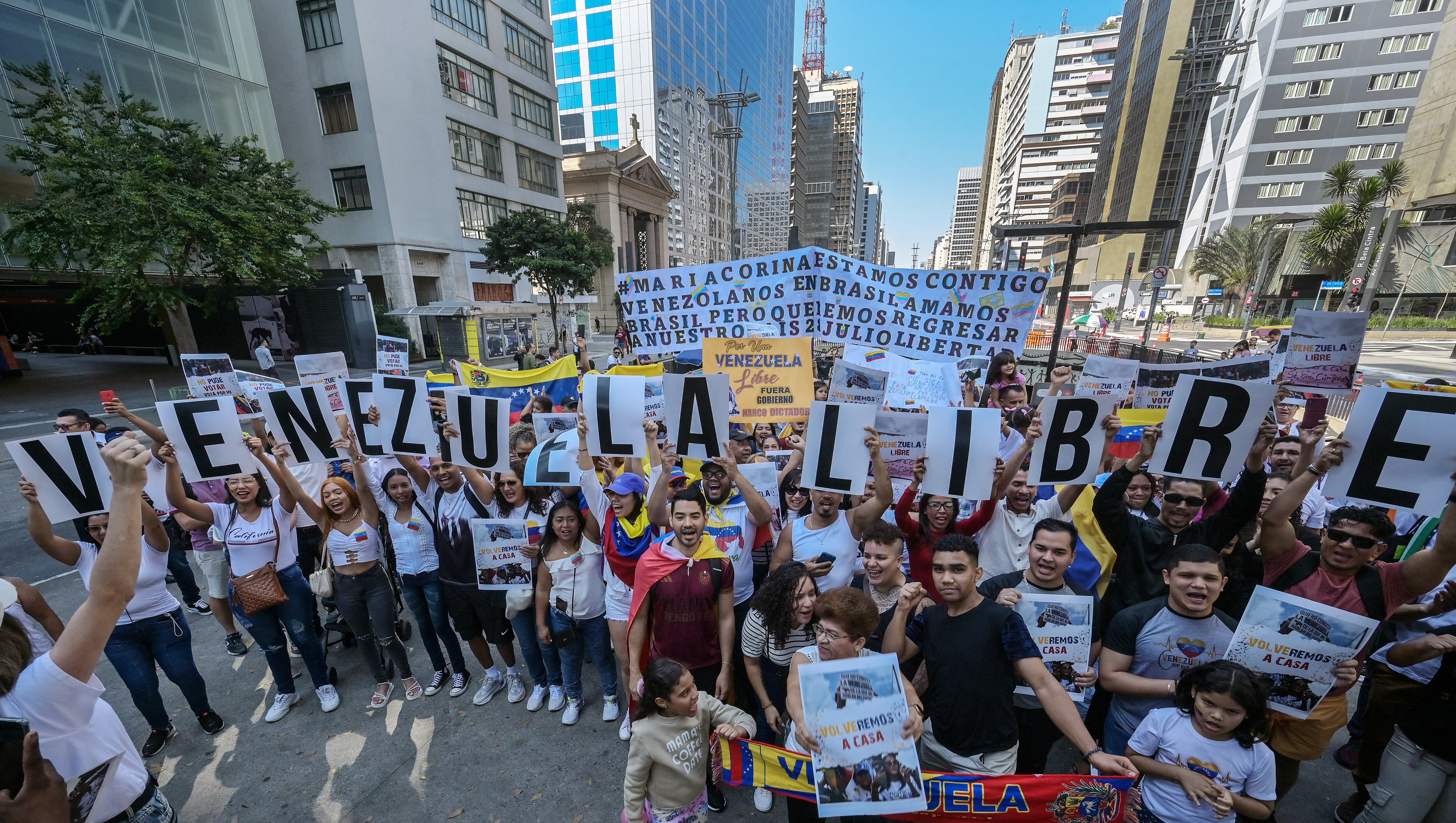 Ciudadanos venezolanos sostienen pancartas con letras que dicen 'VENEZUELA LIBRE' en protesta en apoyo a la oposición venezolana en la Avenida Paulista, en Sao Paulo, Brasil, el 28 de julio de 2024 (Foto de Nelson ALMEIDA / AFP)