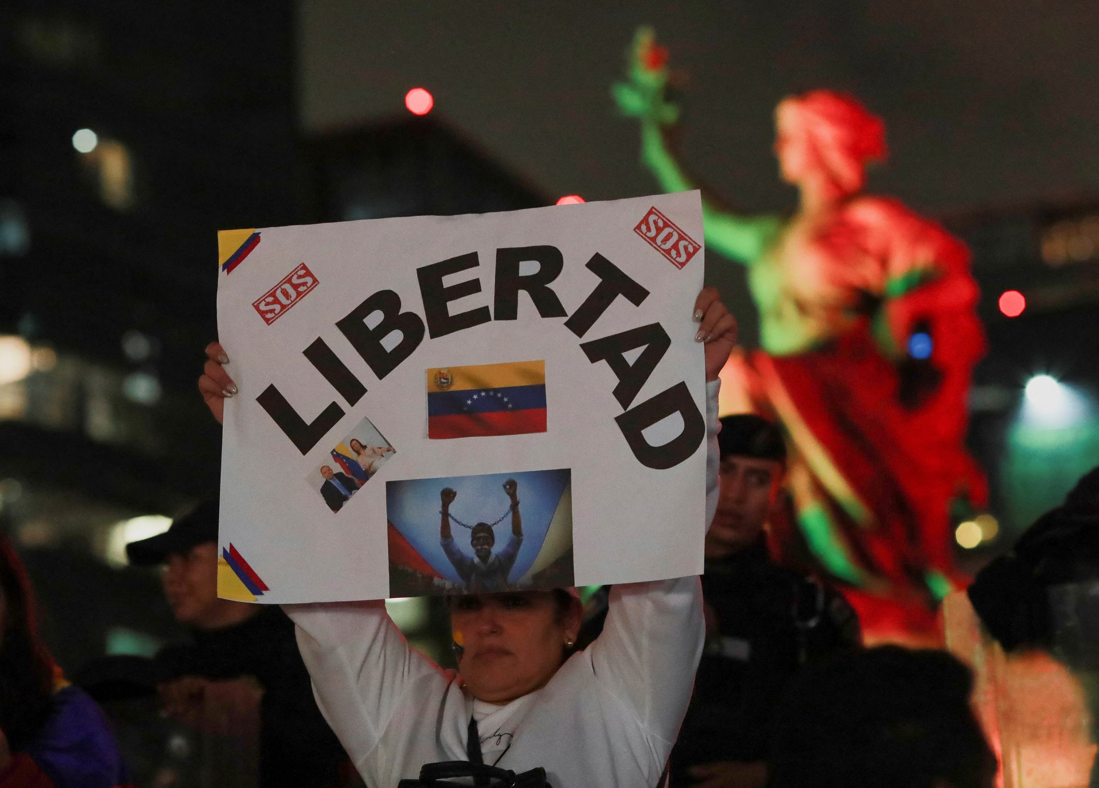 Una venezolana que vive en México sostiene un cartel mientras participa en una protesta contra los resultados electorales que otorgaron al presidente venezolano, Nicolás Maduro, un tercer mandato, en el monumento del Ángel de la Independencia en la Ciudad de México. 
REUTERS/Henry Romero