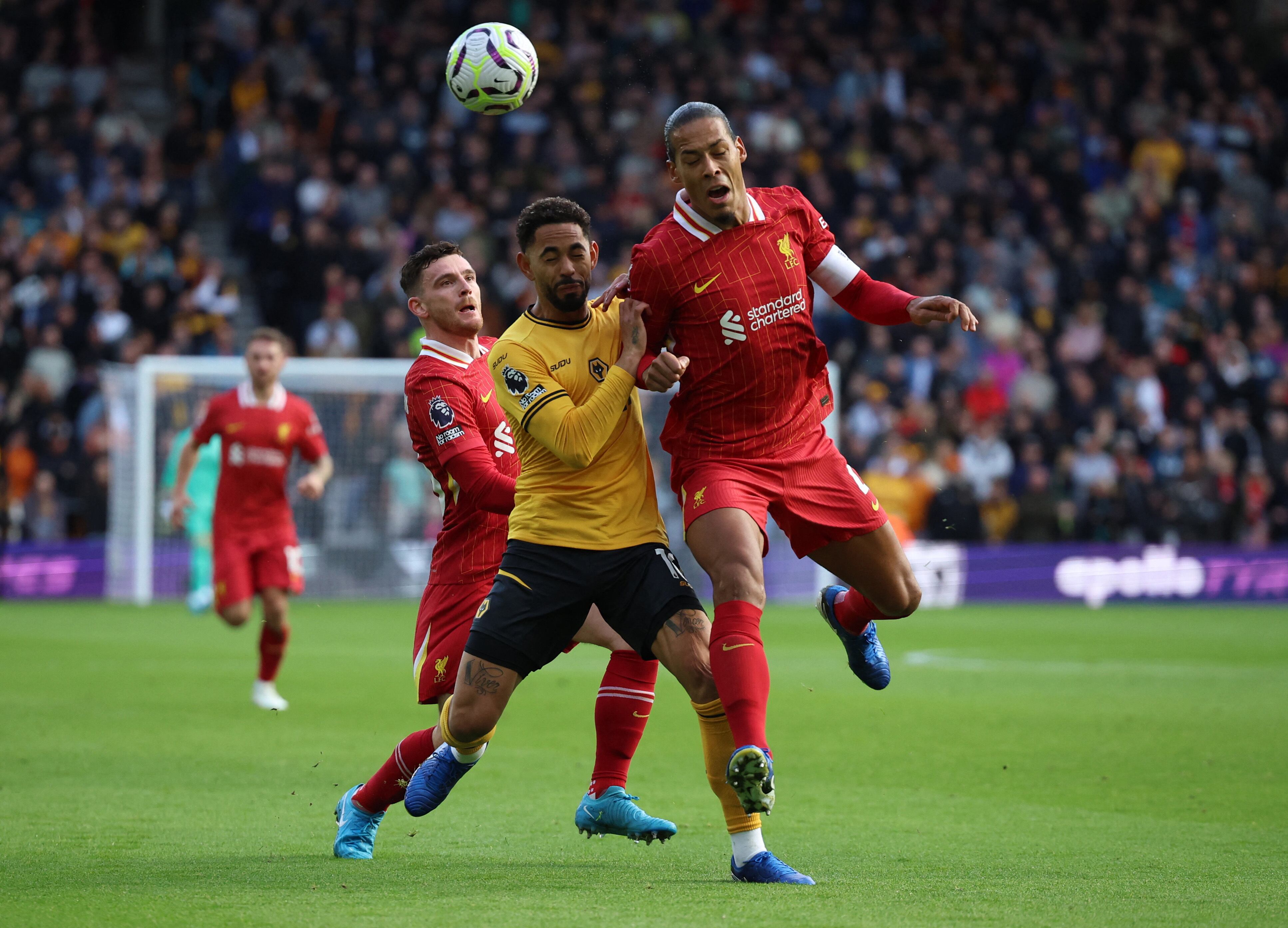 Andrew Robertson, Virgil van Dijk y Matheus Cunha en acción-crédito Phil Noble/REUTERS 