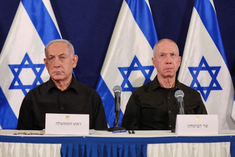 Benjamin Netanyahu, primer ministro de Israel, junto a Yoav Gallant, ministro de Defensa israelí, durante una conferencia de prensa en la base militar de Kirya en Tel Aviv, en octubre de 2023. (ABIR SULTAN POOL/Pool vía REUTERS)