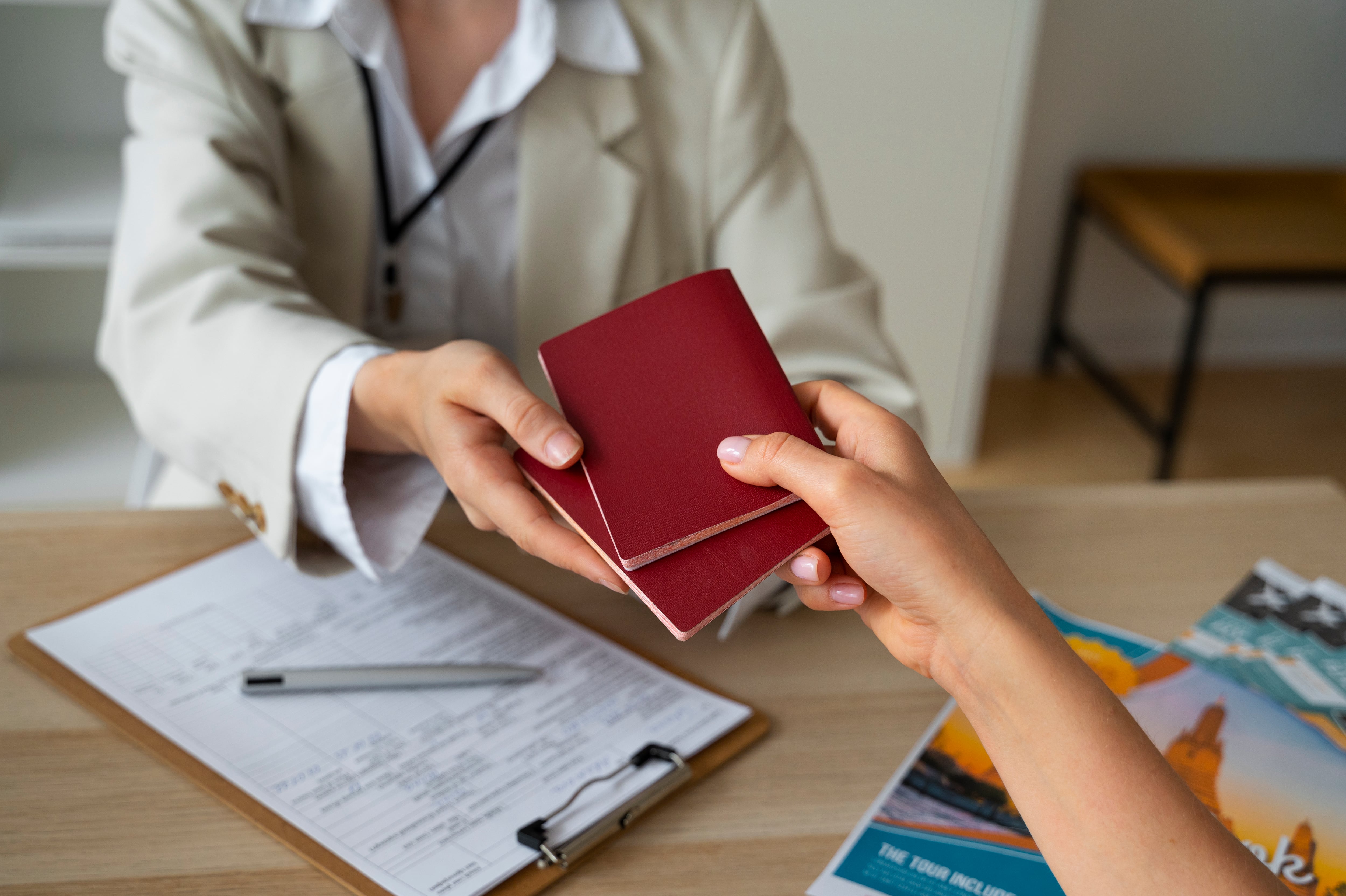 Mujer entregando dos pasaportes (Freepik)