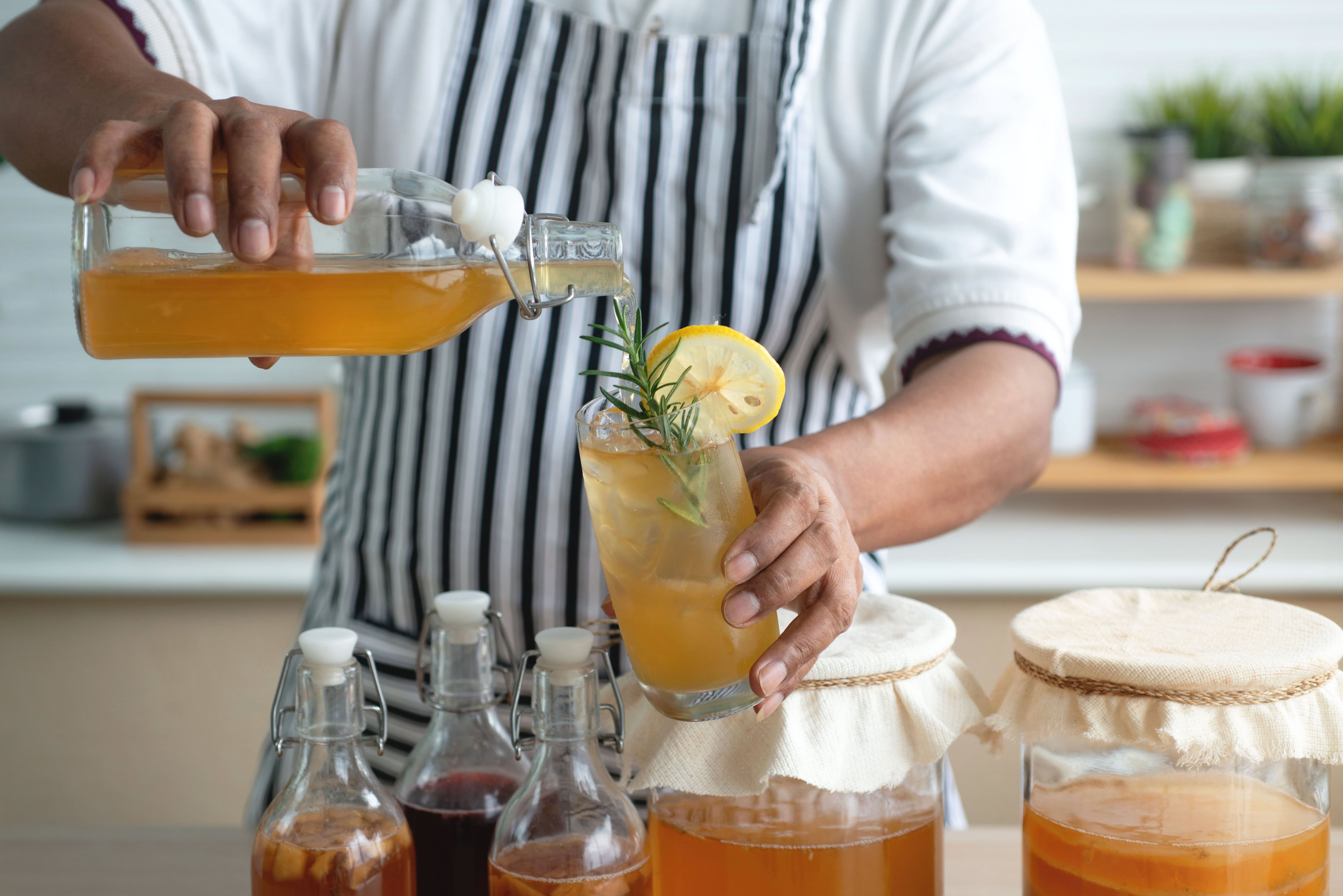 Un hombre sirviendo kombucha (Shutterstock España)