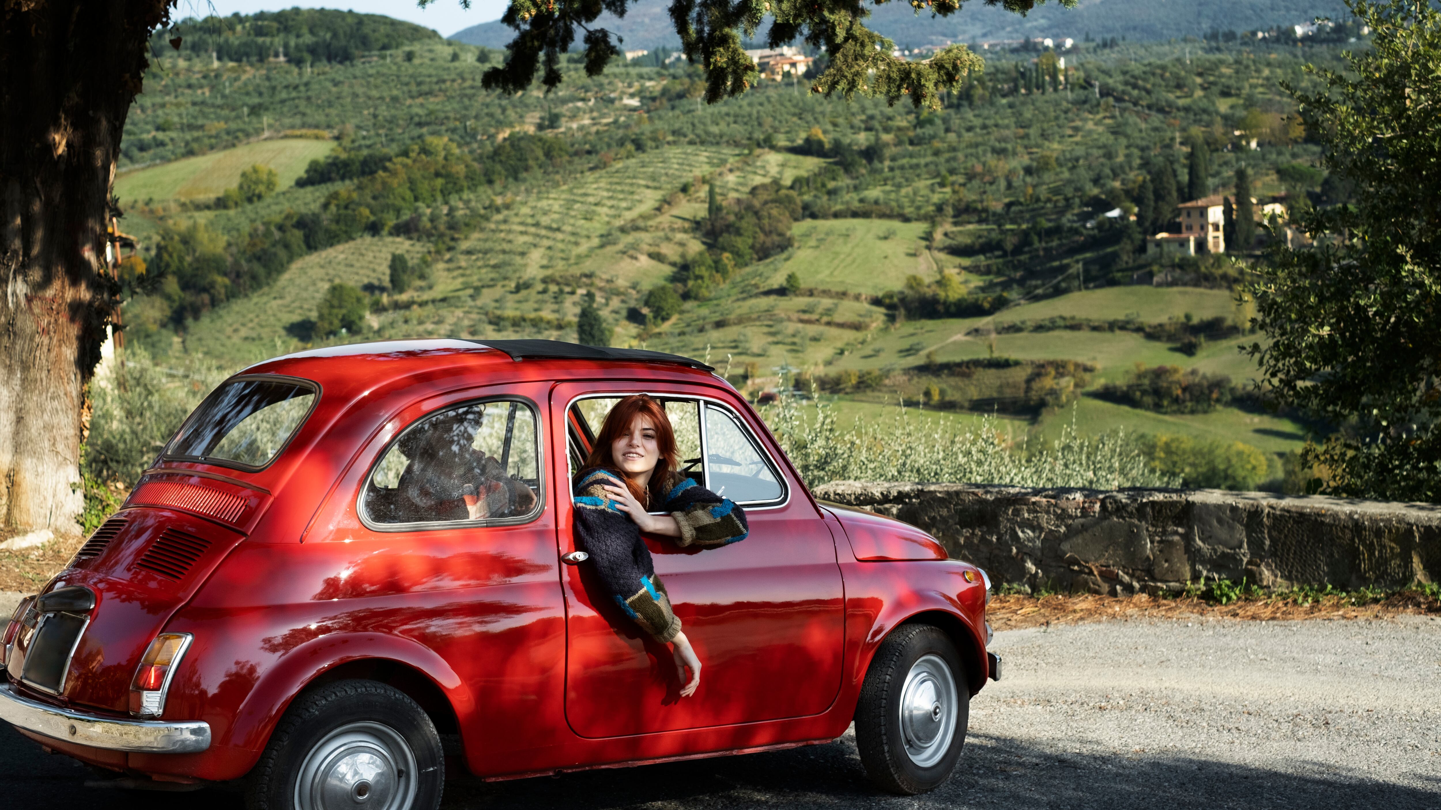 Mujer sonríe en un coche antiguo (Freepik)