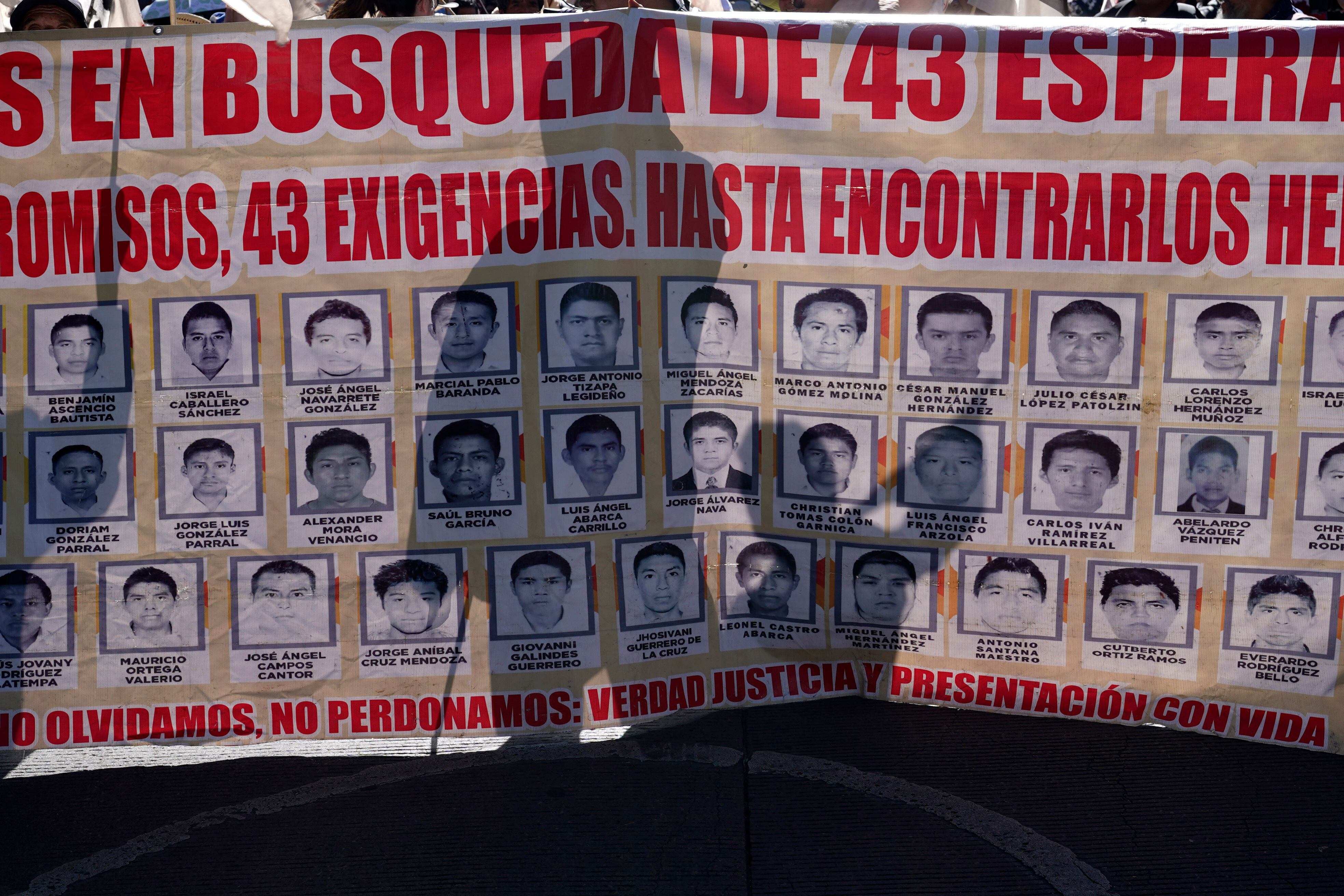 Familiares y simpatizantes de los 43 estudiantes de Ayotzinapa marchan con un gran cartel que muestra sus fotografías y nombres por el noveno aniversario de su desaparición, en Ciudad de México, el martes 26 de septiembre de 2023. (AP Foto/Marco Ugarte)