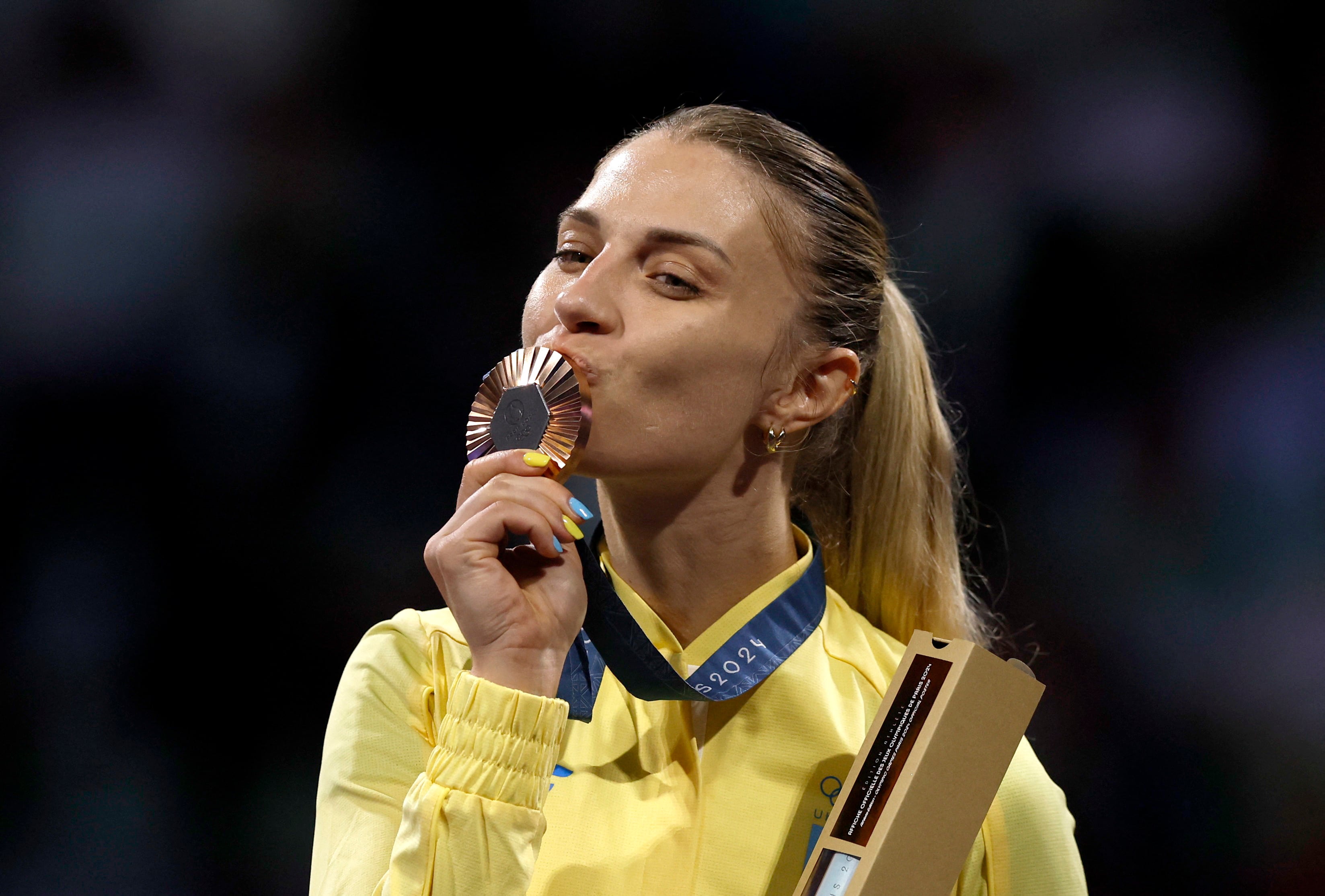 Olga le muestra su medalla al mundo (REUTERS/Albert Gea)