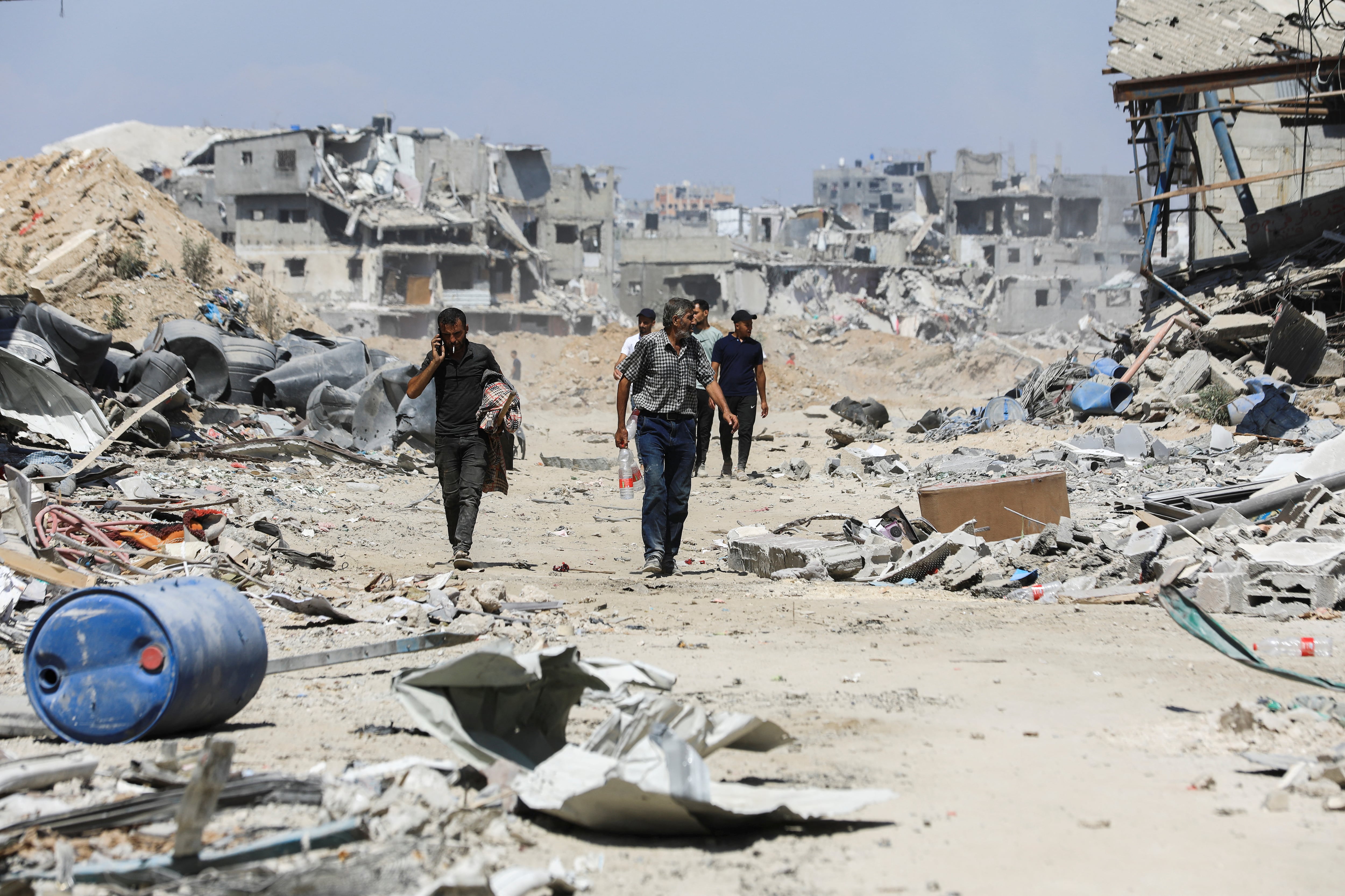 Los palestinos se abren paso mientras inspeccionan los daños, después de que las fuerzas israelíes se retiraran del barrio de Shejaiya, tras una operación terrestre, en medio del conflicto entre Israel y Hamas, en la parte oriental de la ciudad de Gaza. REUTERS/Dawoud Abu Alkas