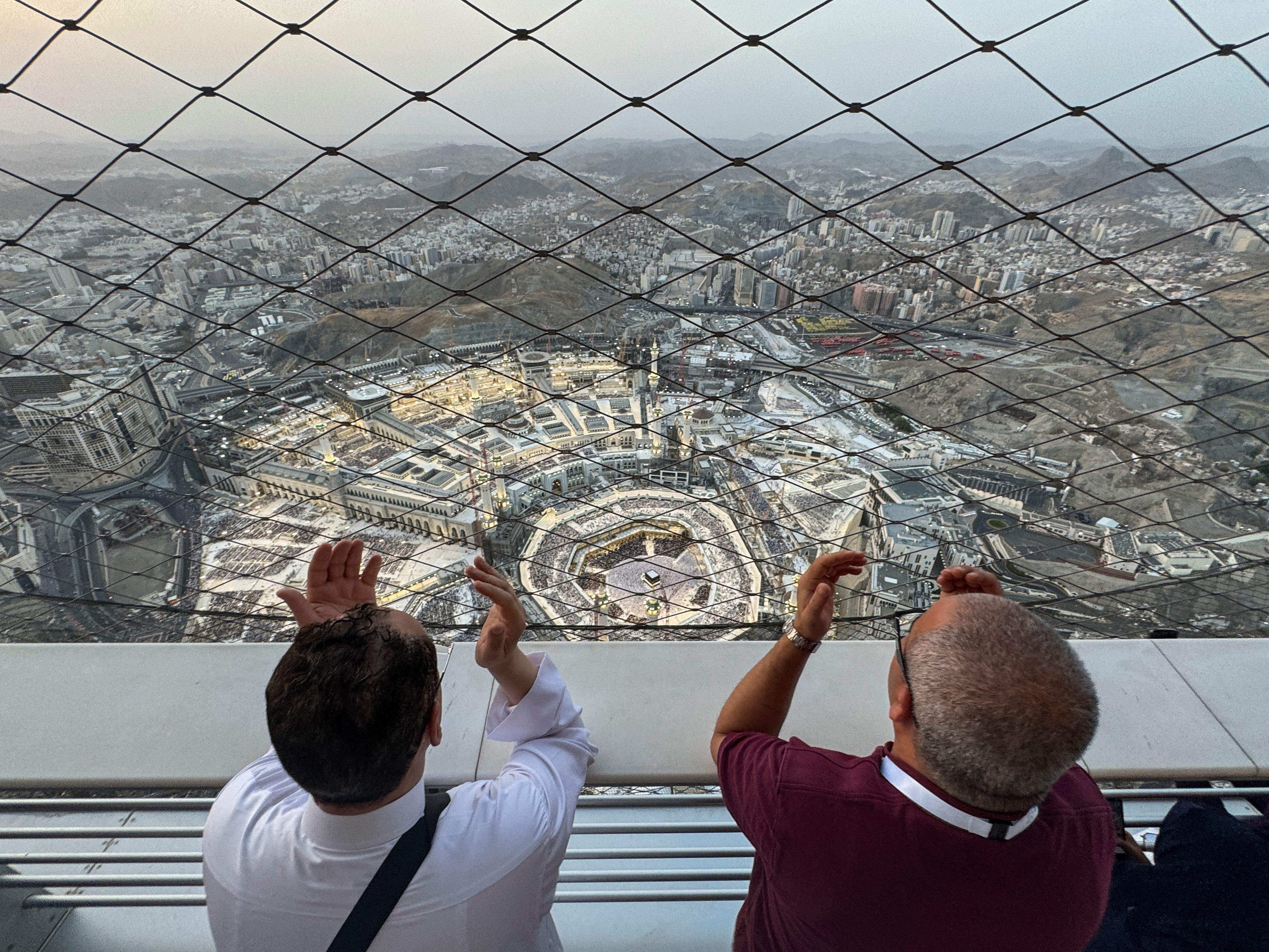 La gente reza en las Torres del Reloj con vistas a la Gran Mezquita, antes de la peregrinación anual haj, en La Meca, Arabia Saudita, el 11 de junio de 2024. REUTERS/Saleh Salem