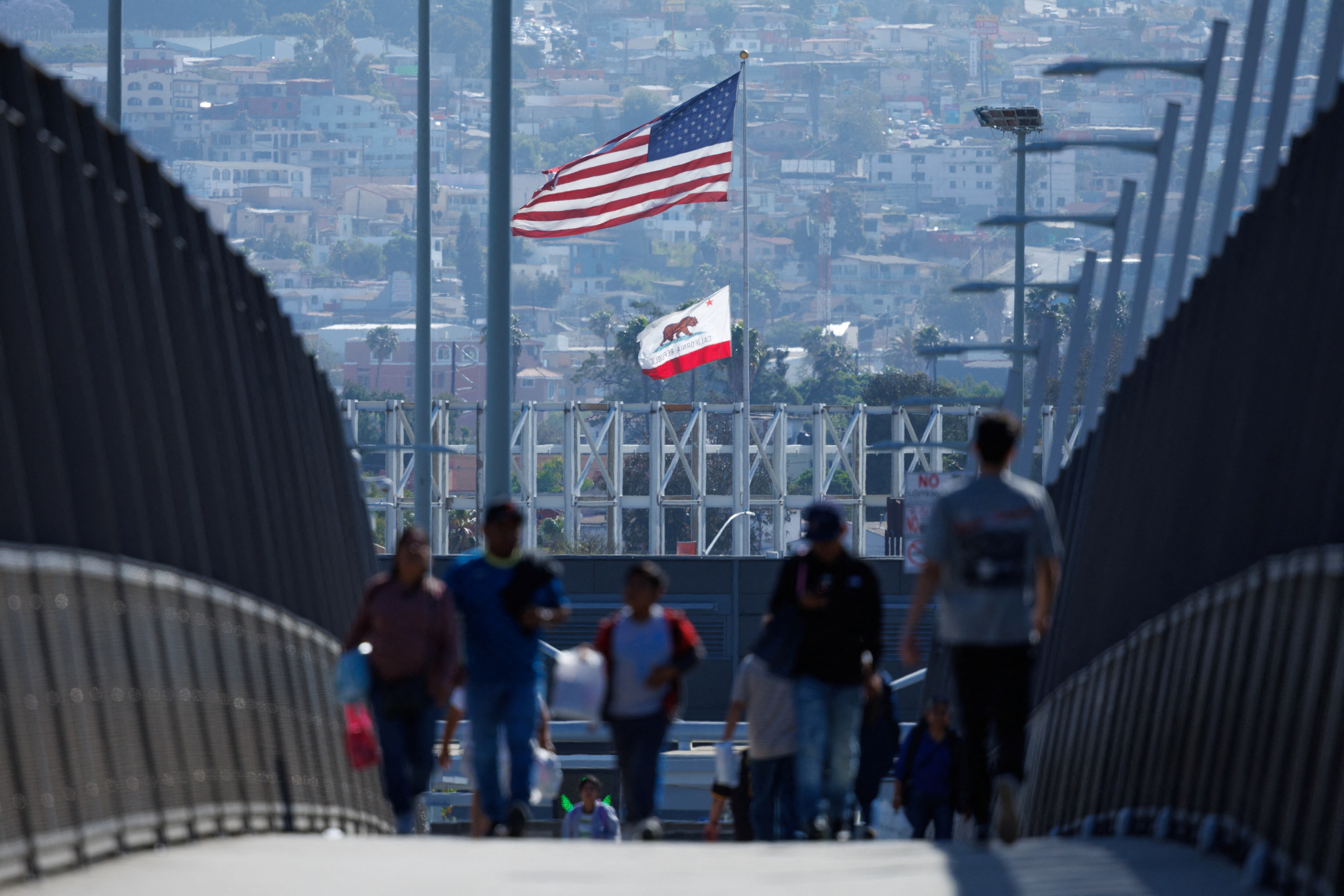 Peatones caminan por una pasarela cerca del paso fronterizo entre México y Estados Unidos en la frontera de San Ysidro en San Diego, California a fines de mayo (REUTERS/Mike Blake)