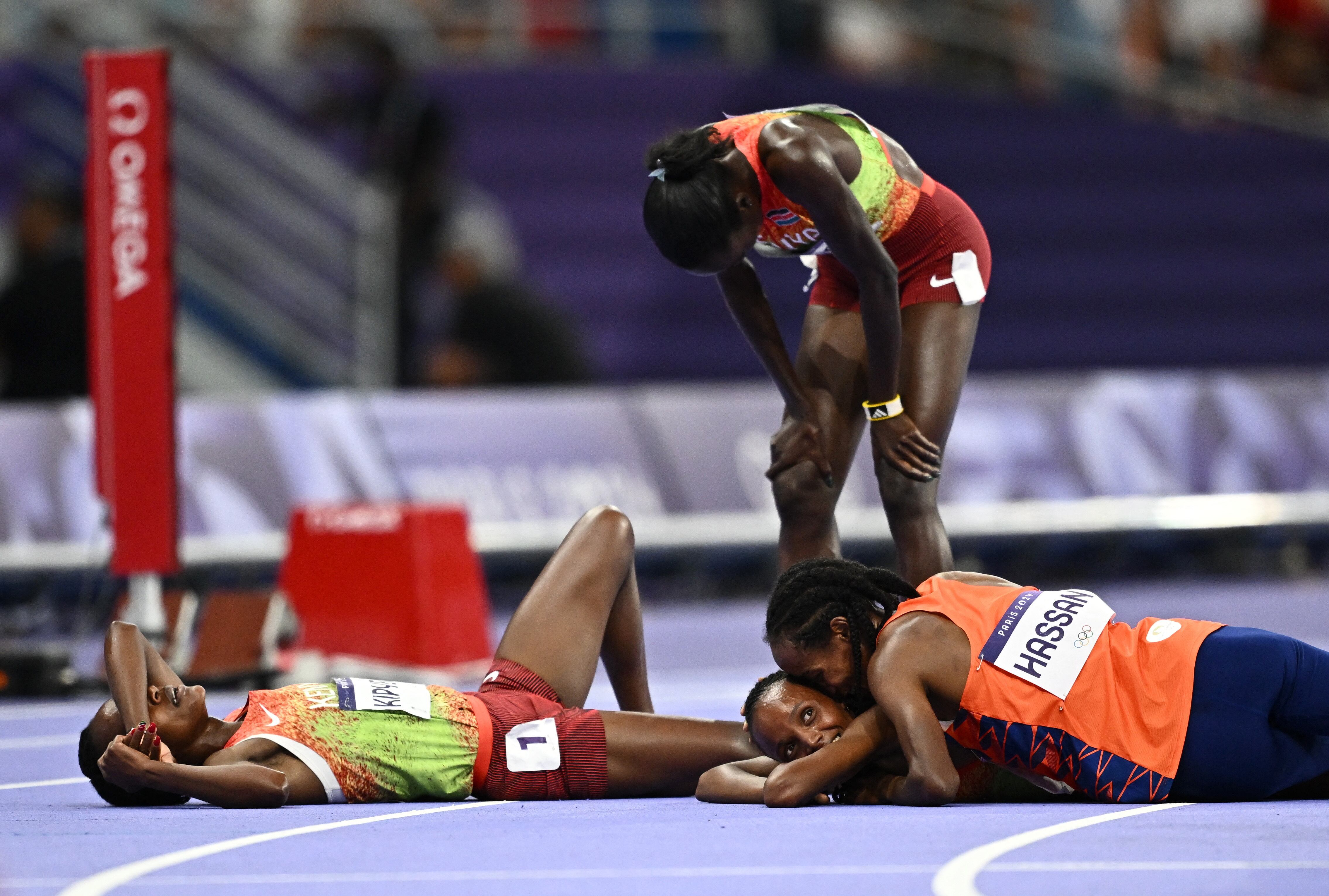 Beatrice Chebet celebra la medalla dorada con Sifan Hassan, quien se quedó con la de plata. Junto a ellas, la decepción de Faith Kipyegon (REUTERS/Dylan Martinez)