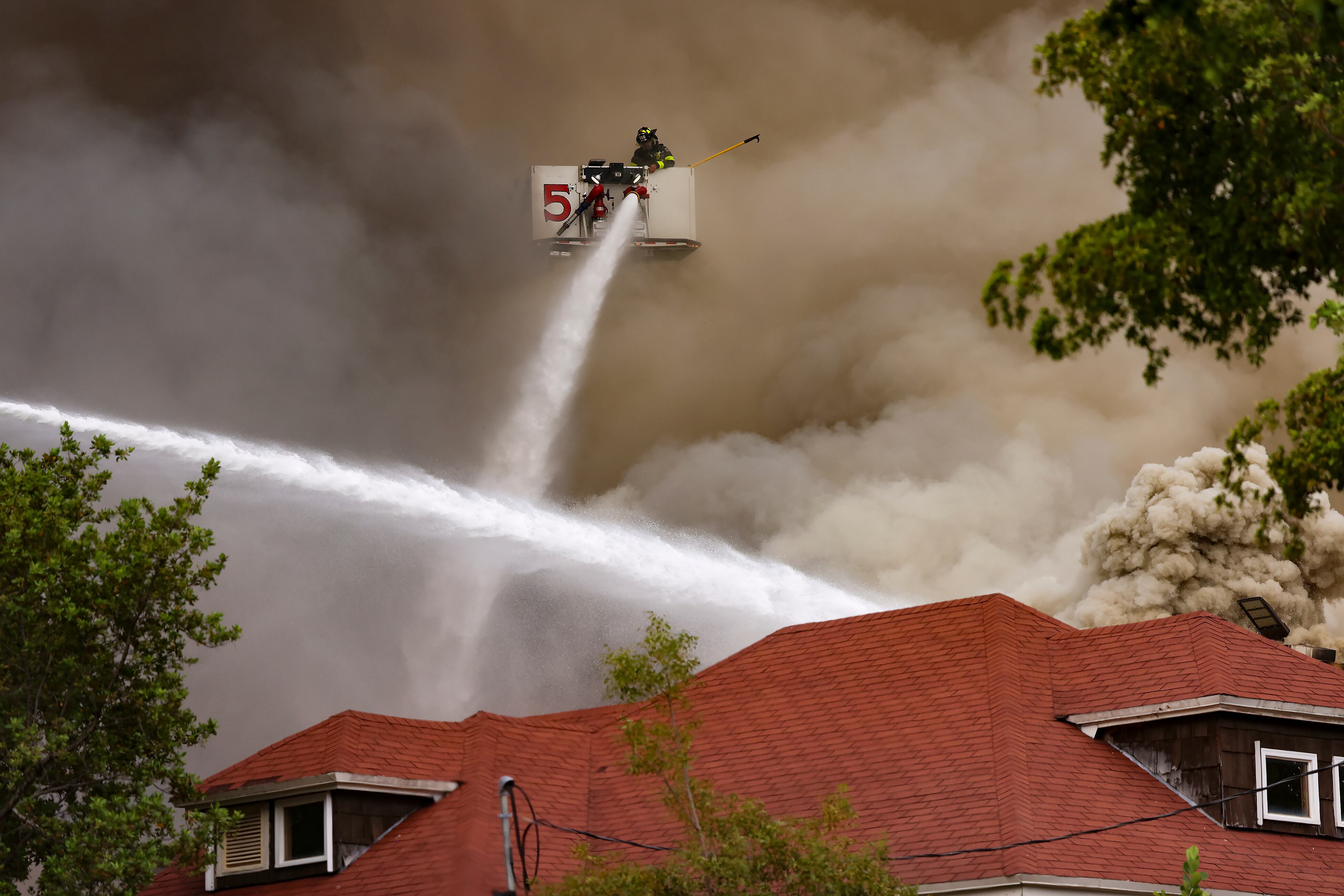 Cuadrillas de bomberos y policías de Miami combaten un incendio en un edificio de apartamentos (Carl Juste/Miami Herald vía AP)