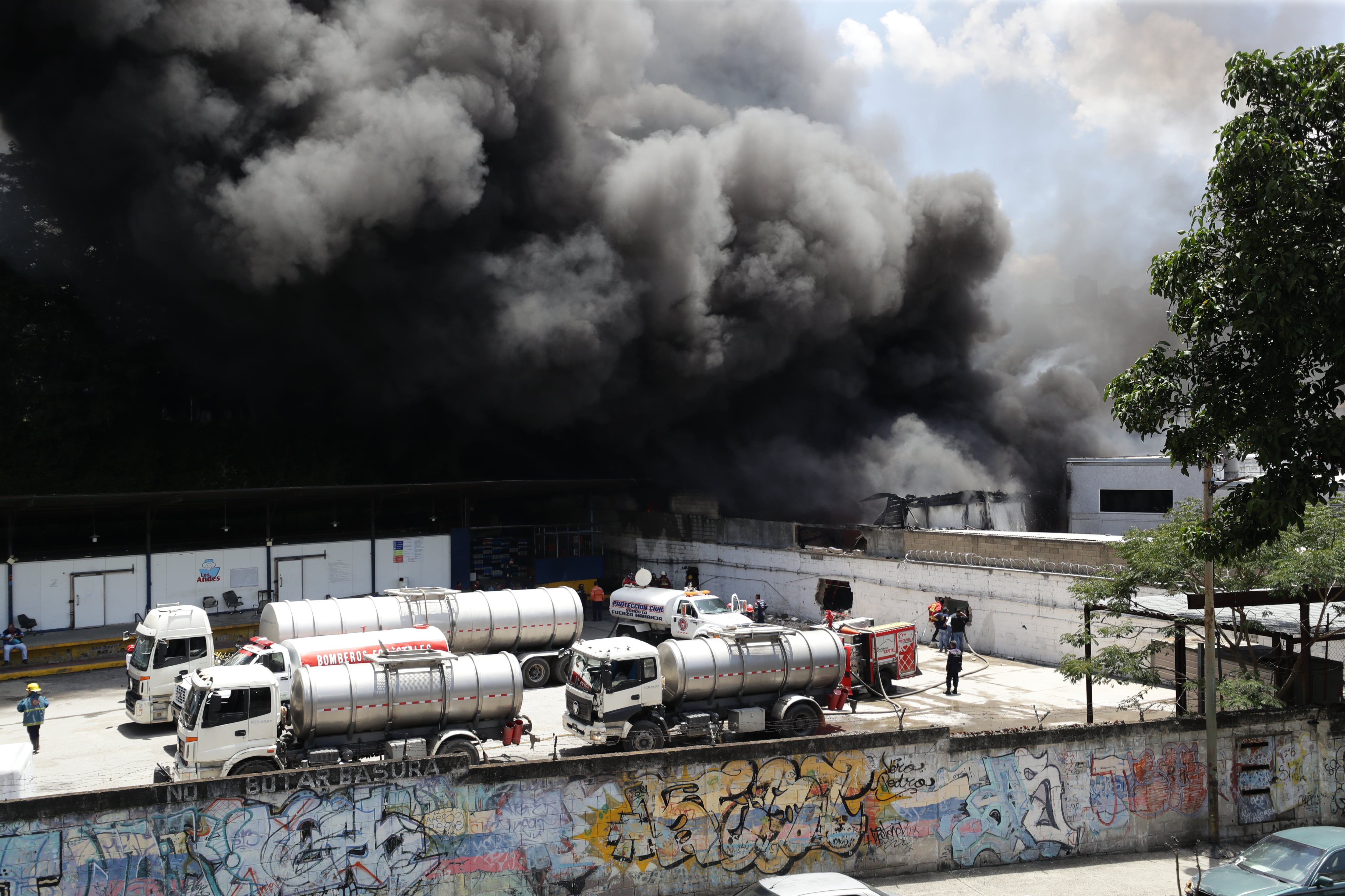 Los bomberos controlan un incendio en una planta de ensamblaje de motocicletas en Caracas