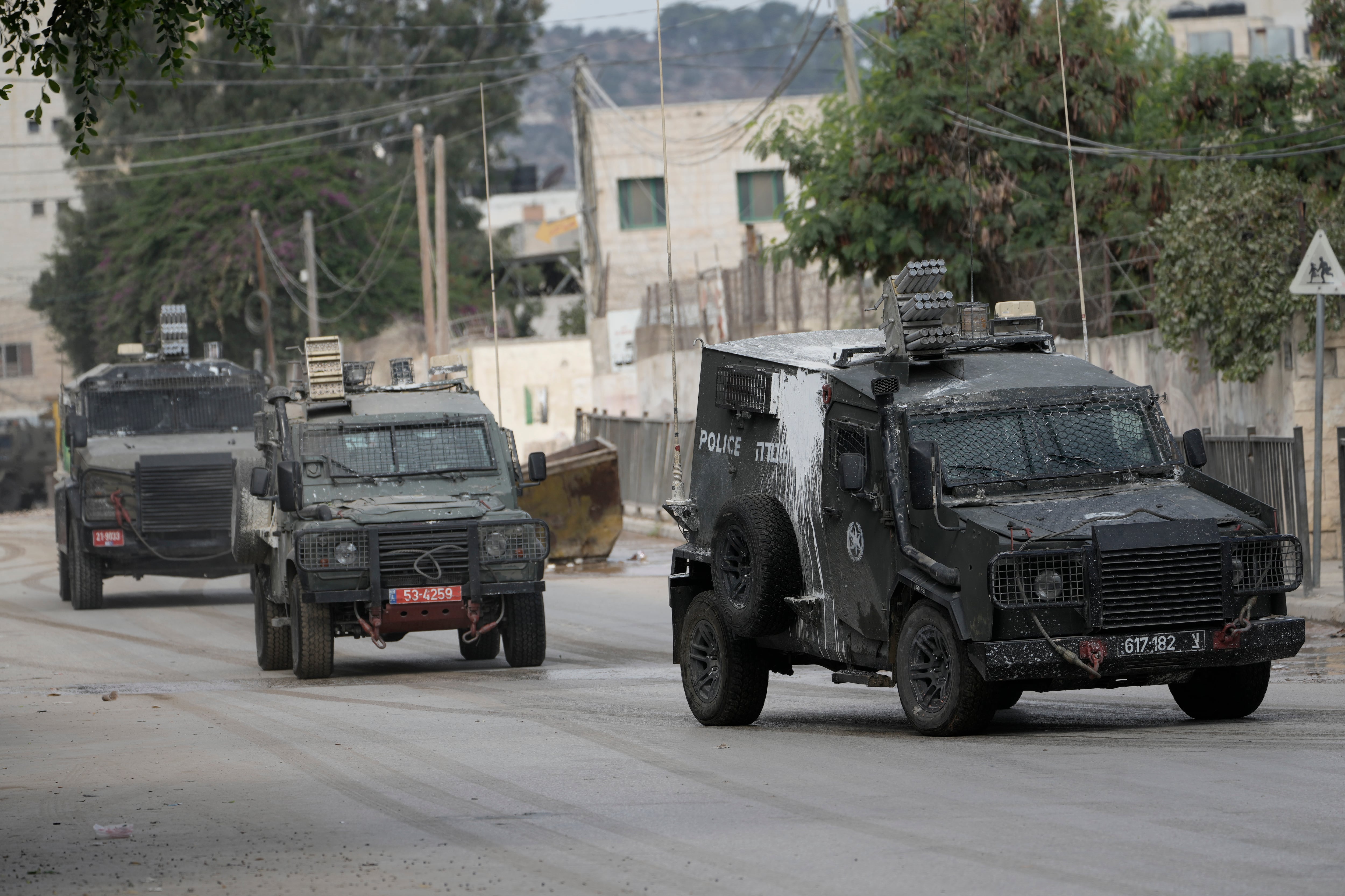 Vehículos blindados israelíes circulan por una calle durante una operación militar en la ciudad cisjordana de Yenín (AP Foto/Majdi Mohammed)