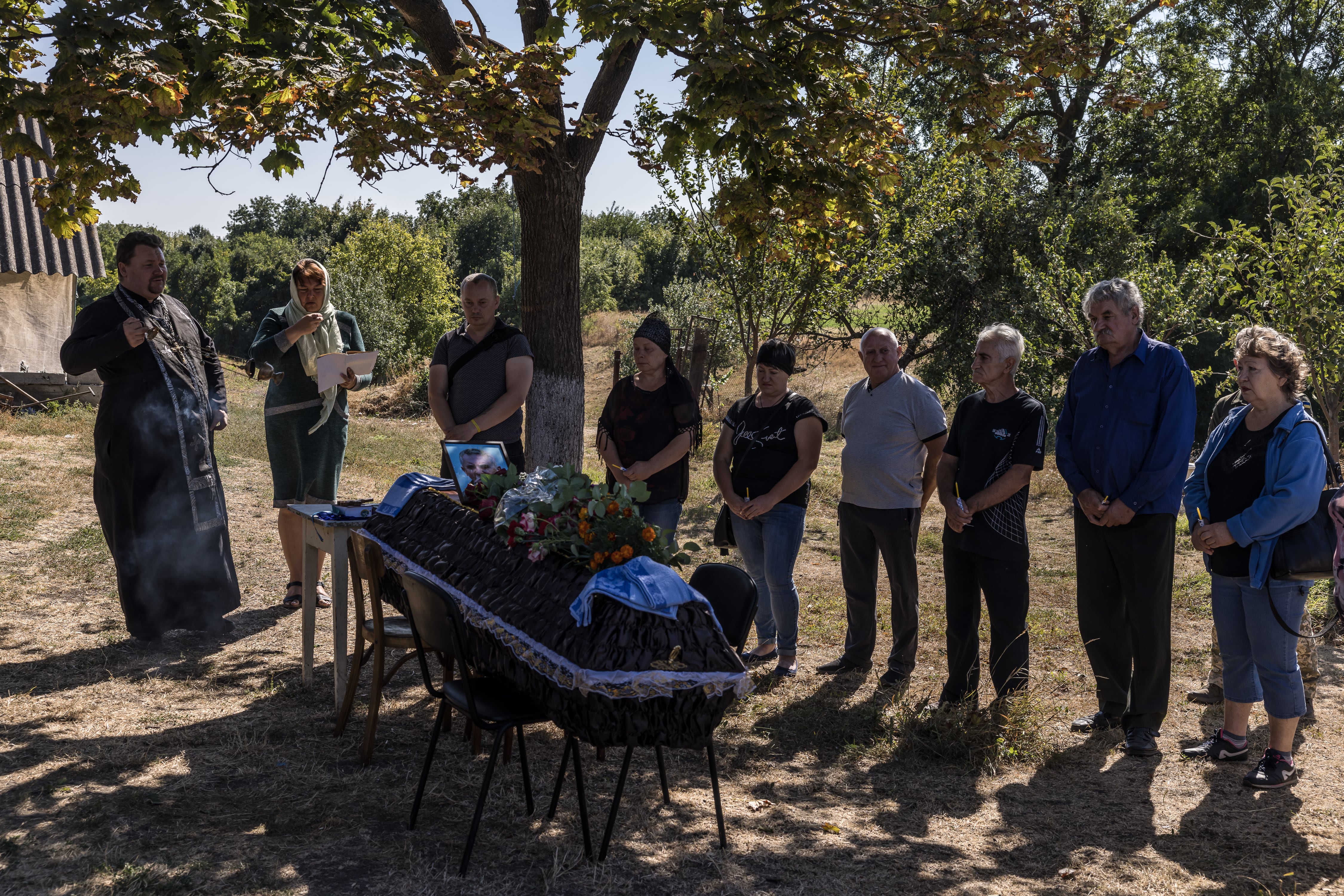 Oleksandr Horodnytskyi ayudó a colocar el ataúd de su padre en el patio de su casa. (Oksana Parafeniuk/The Washington Post)