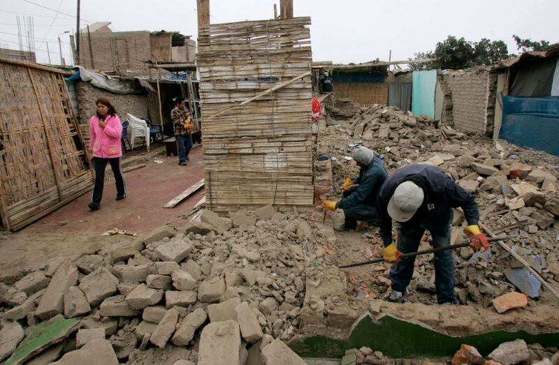 Trabajadores de la construcción retiran rocas de una casa destruida cuando el terremoto azotó la costa central de Perú el 2008. (Reuters / Pilar Olivares)