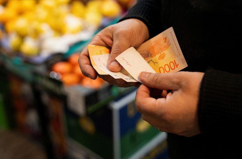 Foto de archivo. Un verdulero cuenta pesos argentinos en un mercado local en Buenos Aires. REUTERS/Irina Dambrauskas