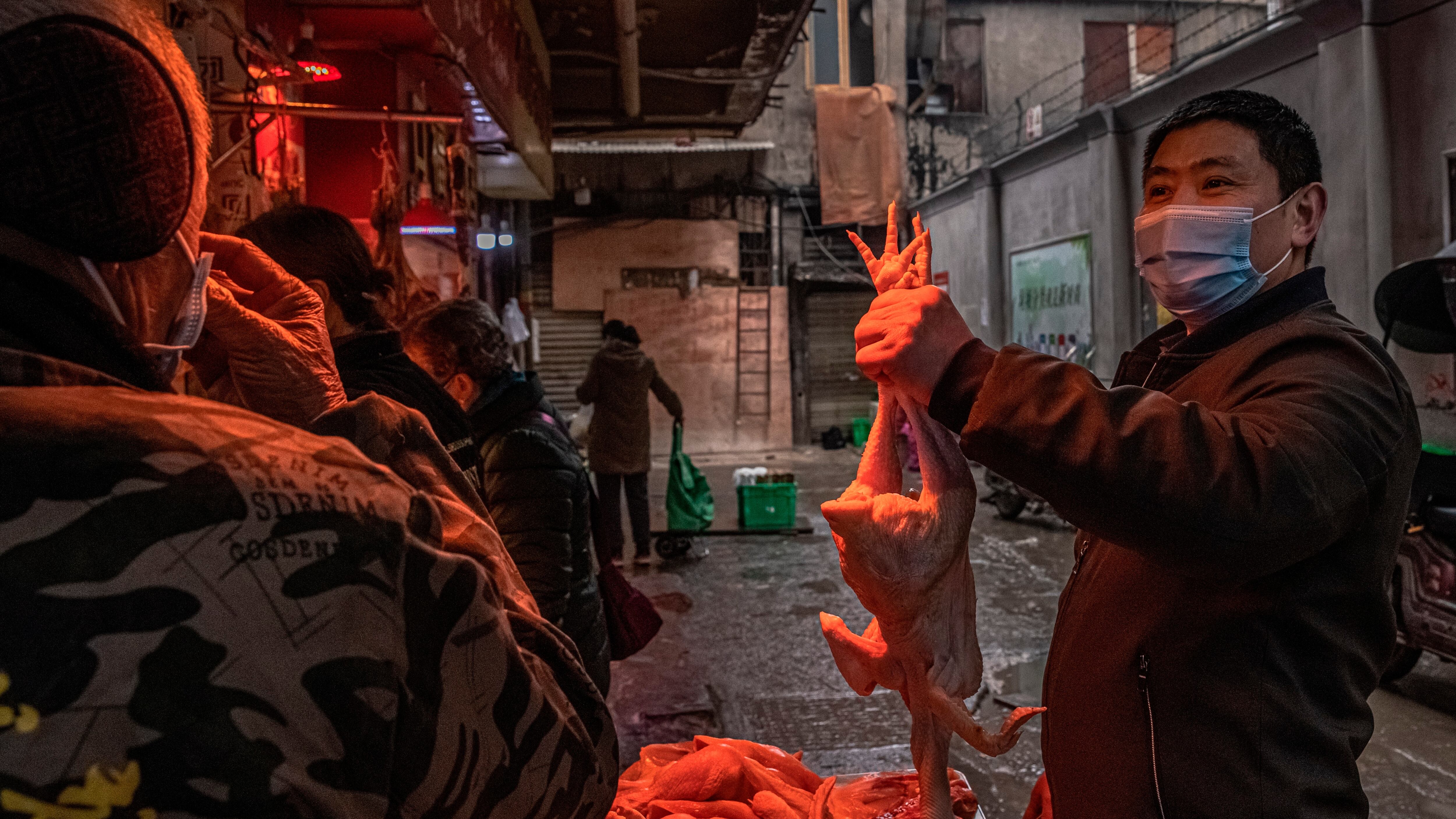 Un hombre con una mascarilla escoge un pollo en el mercado callejero de Wuhan, China. EFE/EPA/ROMAN PILIPEY/Archivo
