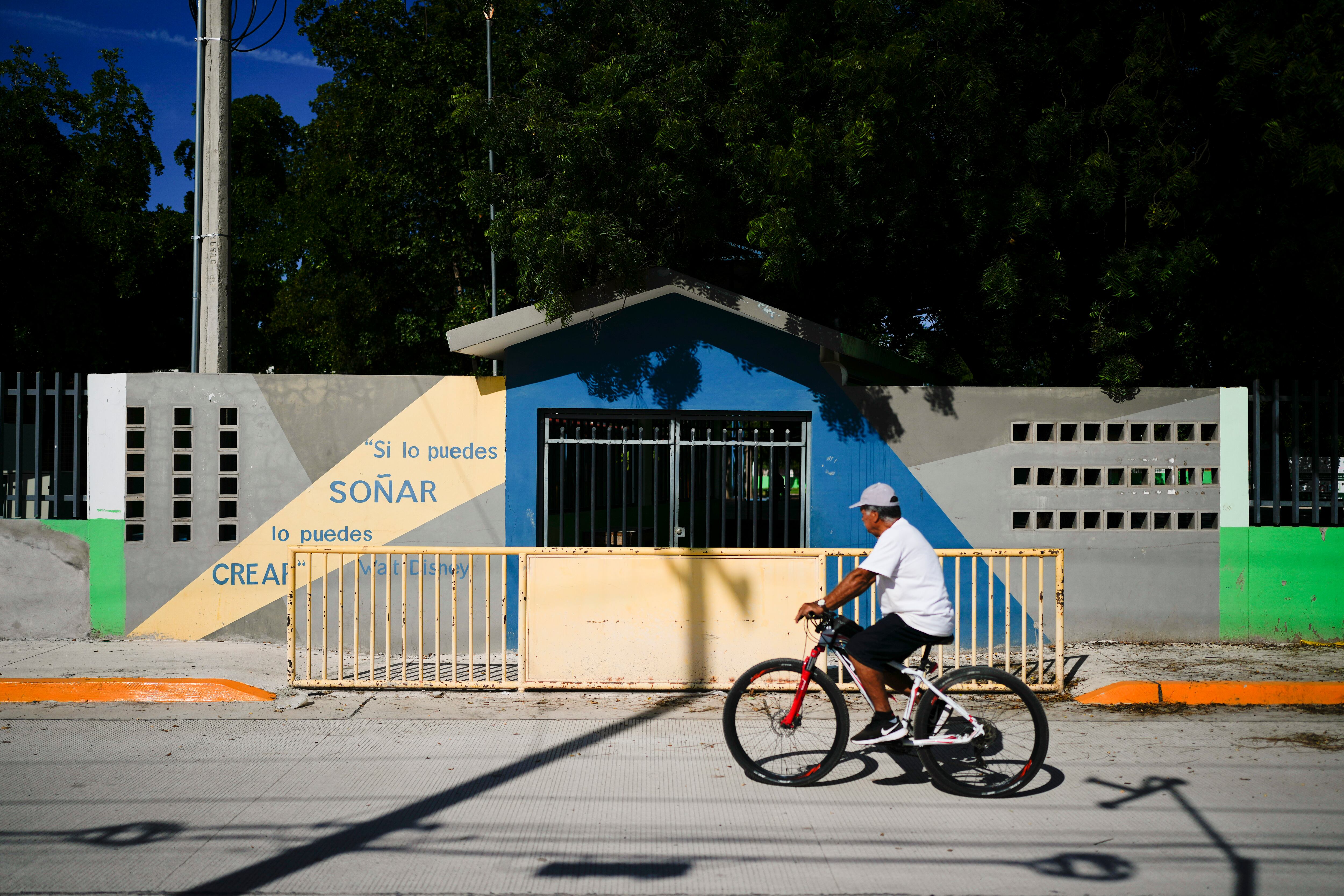 Un hombre pasa en su bicicleta frente a la primaria Lázaro Cárdenas, que fue cerrada temporalmente por la violencia en Culiacán, Sinaloa, en el norte de México, el jueves 19 de septiembre de 2024. (AP Foto/Eduardo Verdugo)