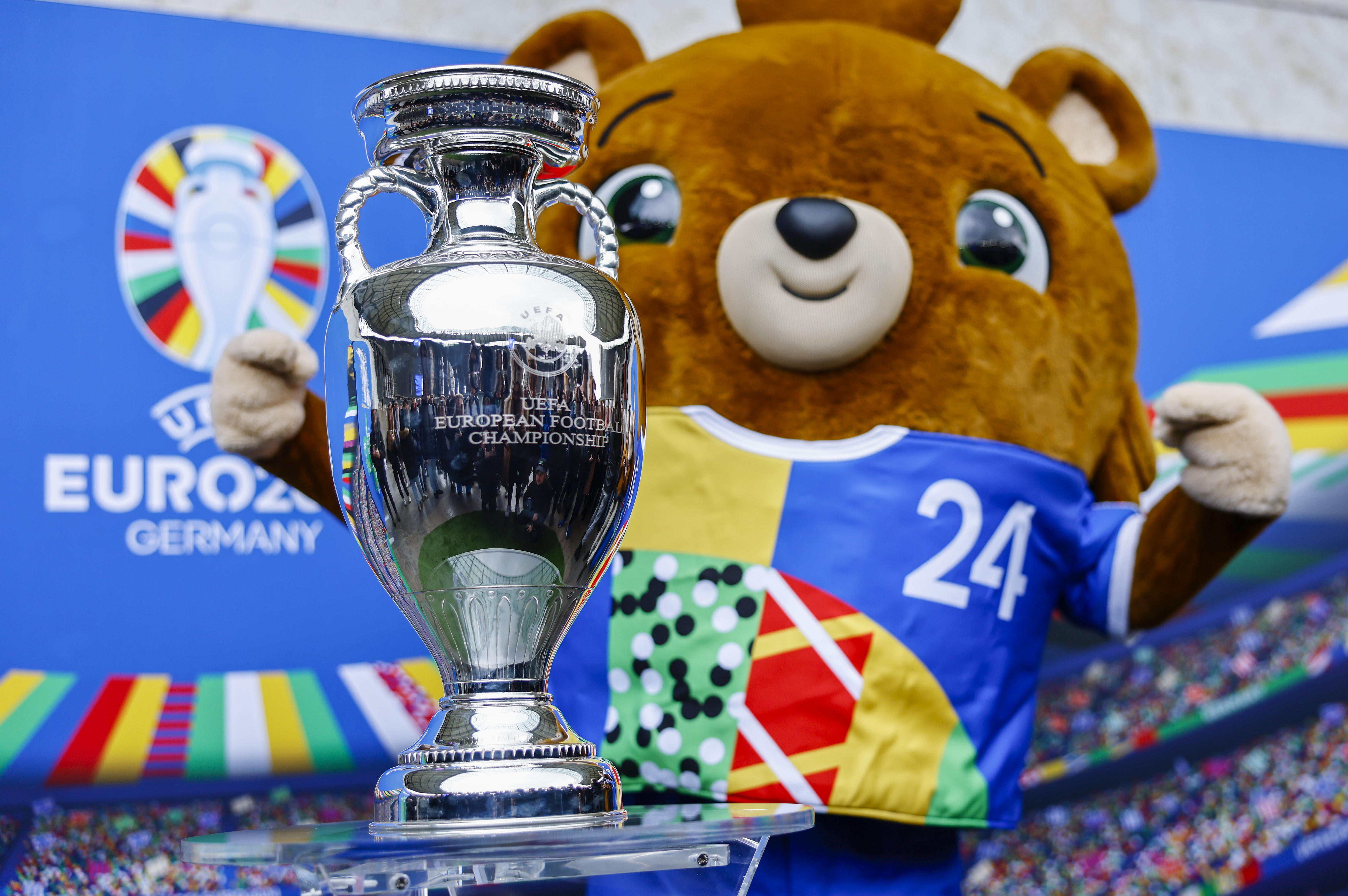 La mascota de la Eurocopa 2024, Albart, posa junto al trofeo del torneo (EFE/EPA/HANNIBAL HANSCHKE)