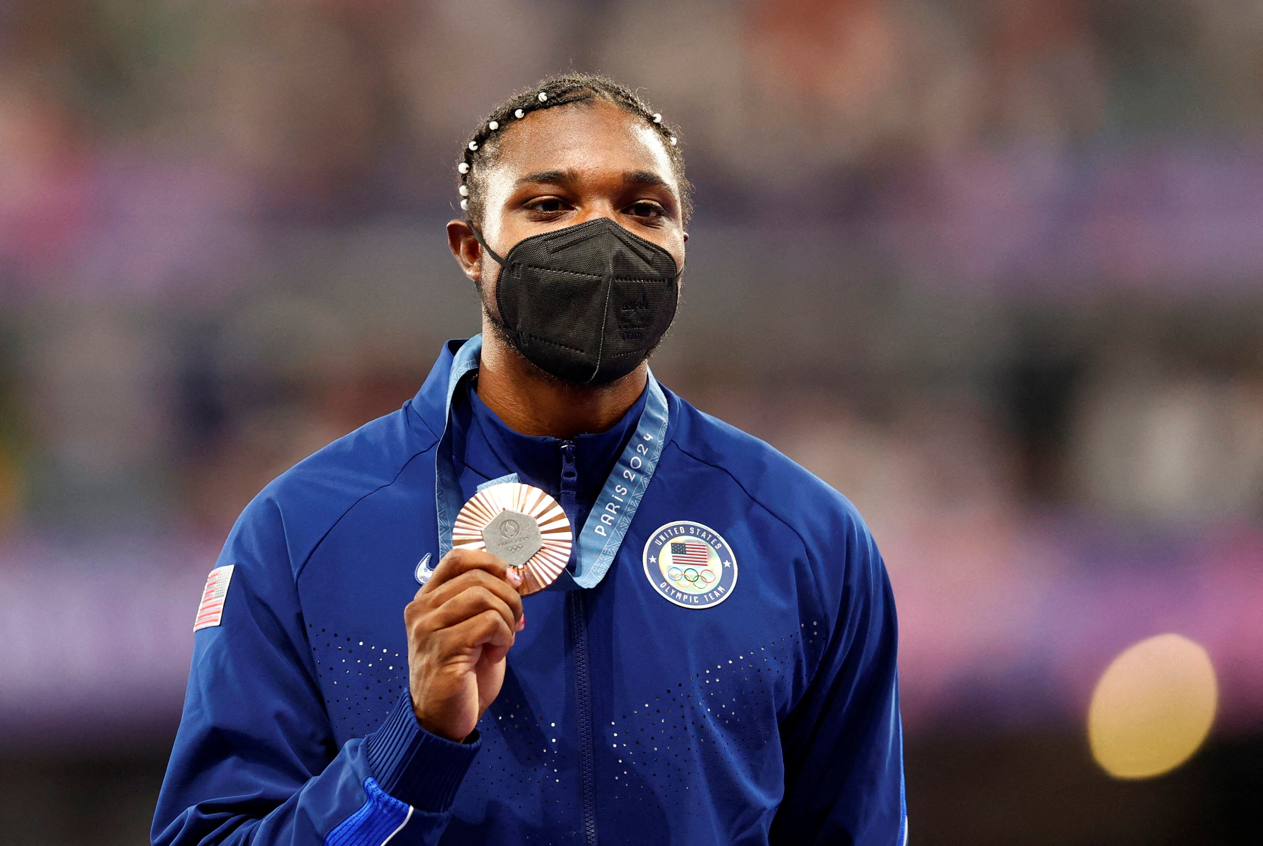 Noah Lyles con barbijo en el podio recibiendo su medalla de bronce. El estadounidense corrió la prueba de 200 metros con Covid-19 (REUTERS/Alina Smutko)