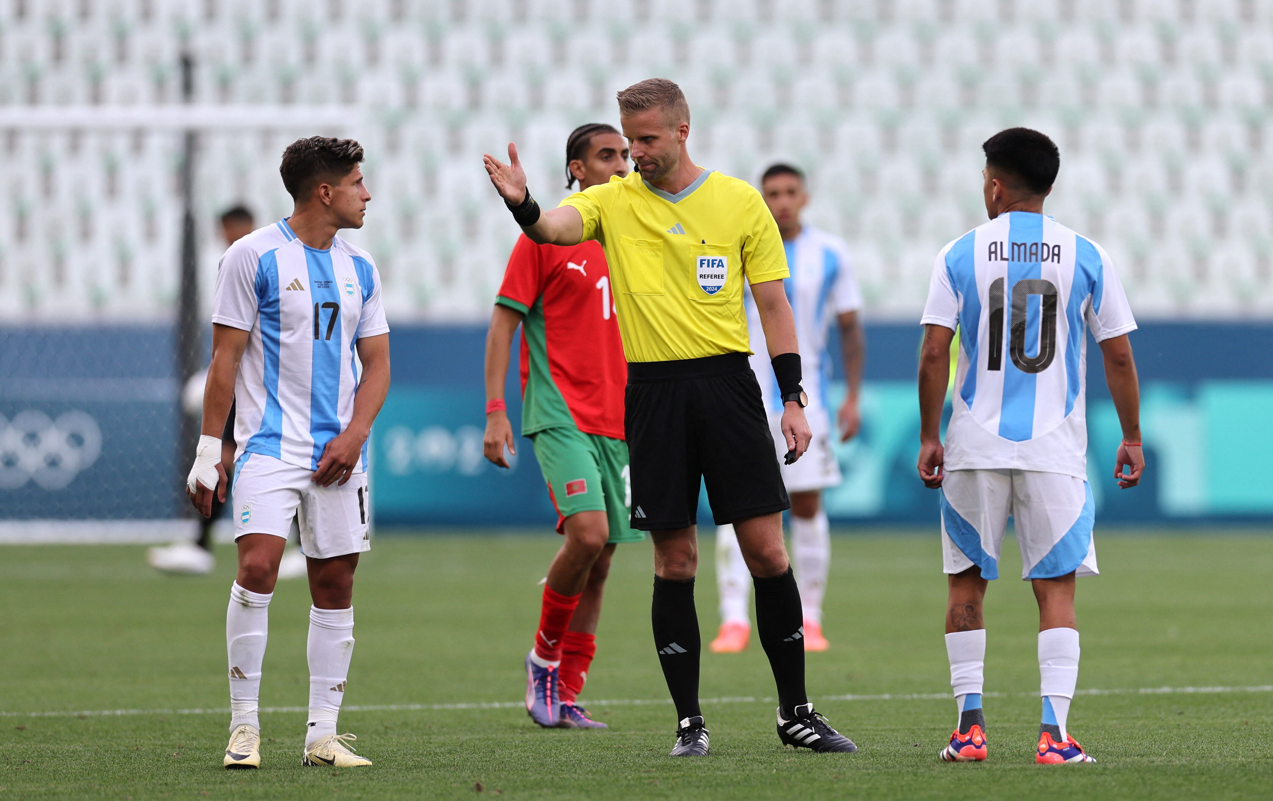 Almada y Giuliano Simeone le protestan al árbitro Glenn Nyberg durante el duelo de la polémica (REUTERS/Thaier Al-Sudani)