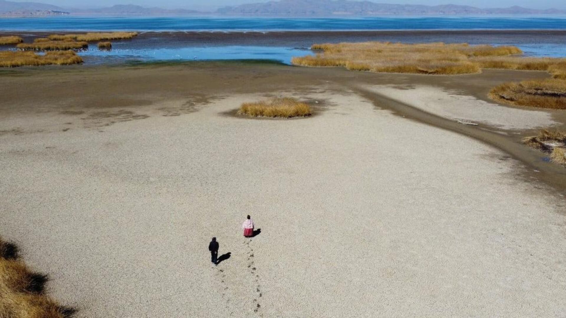 Ciudadanos puneños caminan sobre lago seco.