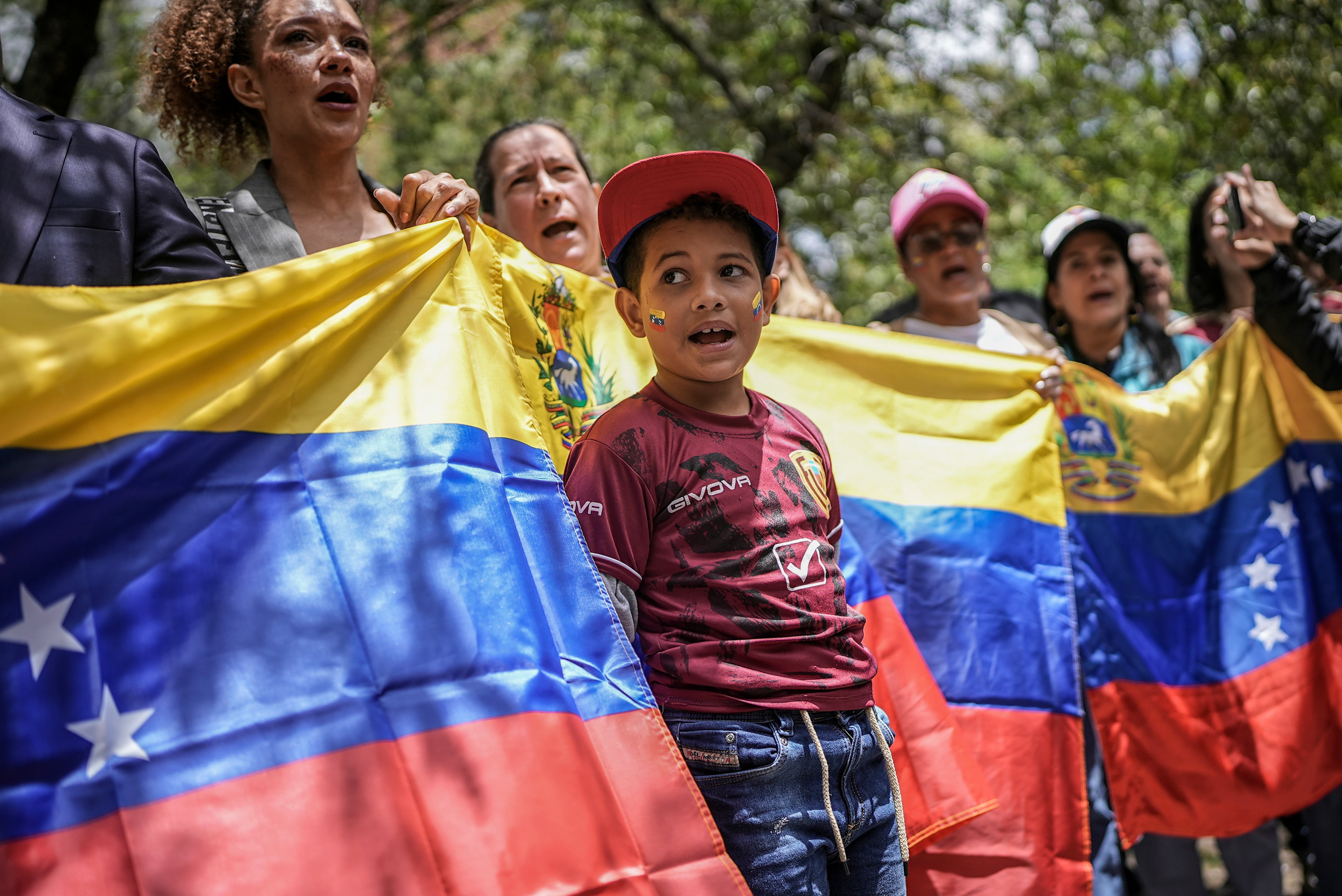 Manifestantes con una bandera venezolana se concentran en el consulado de Venezuela para protestar contra los resultados de las controvertidas elecciones presidenciales que dieron por ganador a Nicolás Maduro en Bogotá, Colombia, el jueves 1 de agosto de 2024. (AP Foto/Iván Valencia)