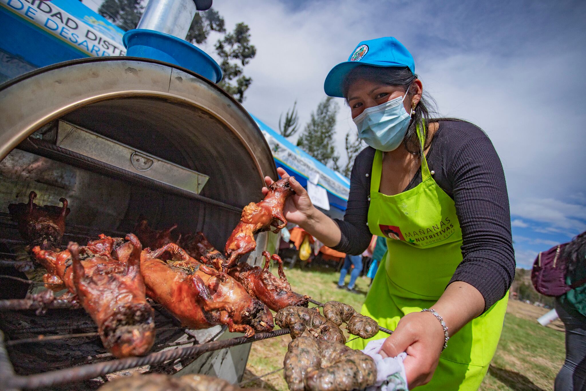 Una mujer cocina cuy al horno